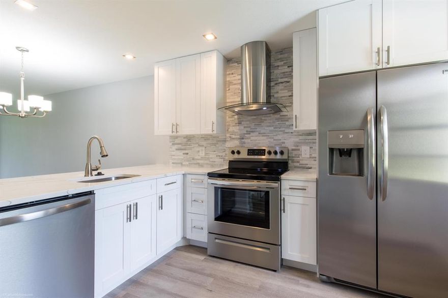 Beautiful - just move right in.  New everything and a gorgeous kitchen with a large slab of quartz at the counter eat-in area.  Bathrooms are beautiful, floors are a perfect distressed wood look with beiges and grey tones.  New AC, newer water heater and new washer/dryer.   No parking lot and cars to look at as this is located in a quiet end building location away from the parking lot with water views from the front also.  Wonderful amenities at the clubhouse with a large gym, pool, spa, exercise classes and full schedule of activities.