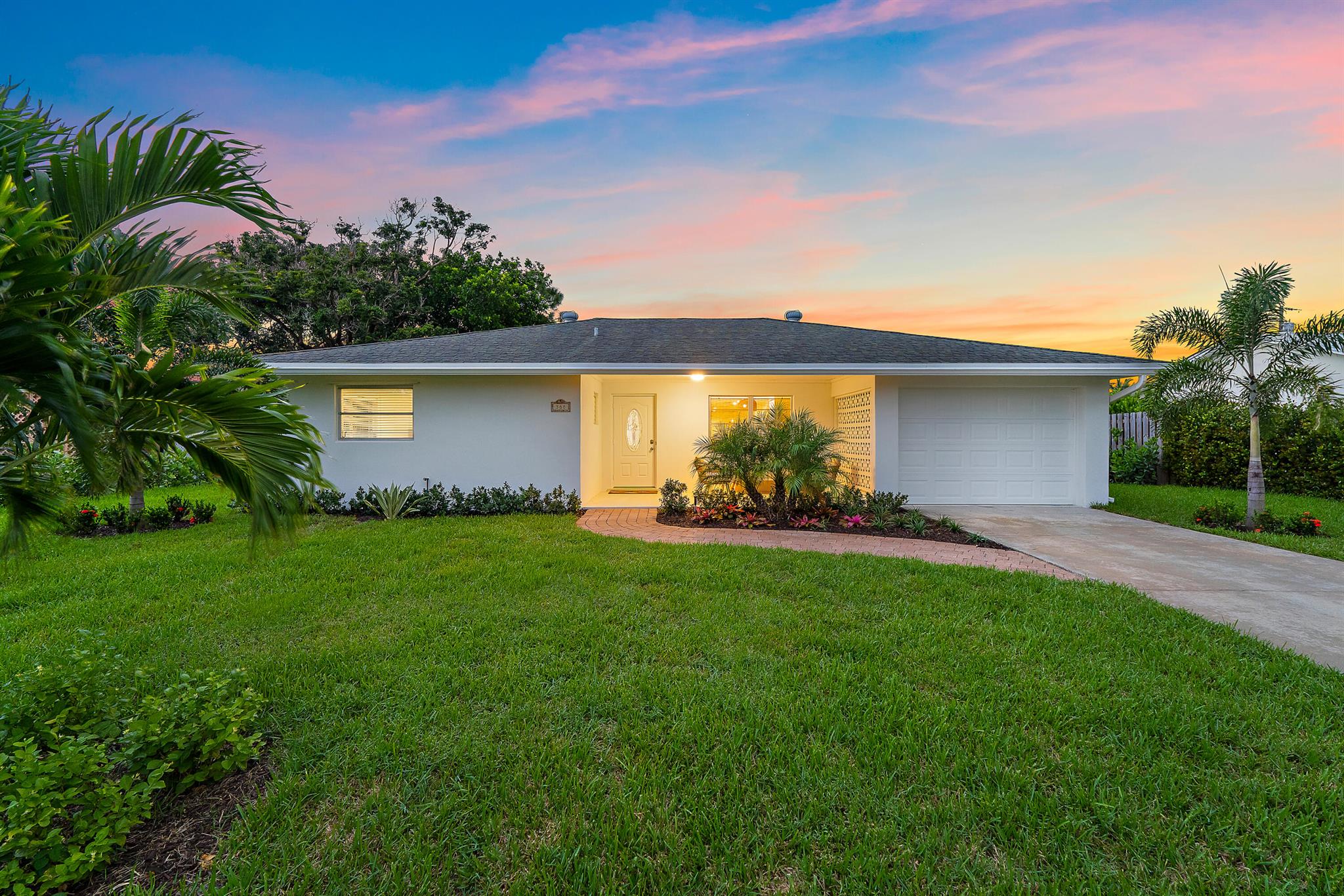 Exquisitely recreated and updated, this single-story Tequesta home blends modern comfort with coastal charm. Just moments from Jupiter Island, the Jupiter Inlet, and Jupiter's pristine beaches, it delivers the best of South Florida living. The reinvented wide-open kitchen is the heart of the home--completely reimagined with white shaker cabinetry, quartz countertops, stainless steel appliances, and an island that seamlessly connects to the dining area and living room. A split floor plan ensures privacy, while plank flooring throughout adds warmth and coastal elegance. Outdoors, enjoy a very large backyard designed for relaxation and entertaining. An open patio invites al fresco dining and evening cocktails under the stars, while the one-car garage provides convenience and storage for