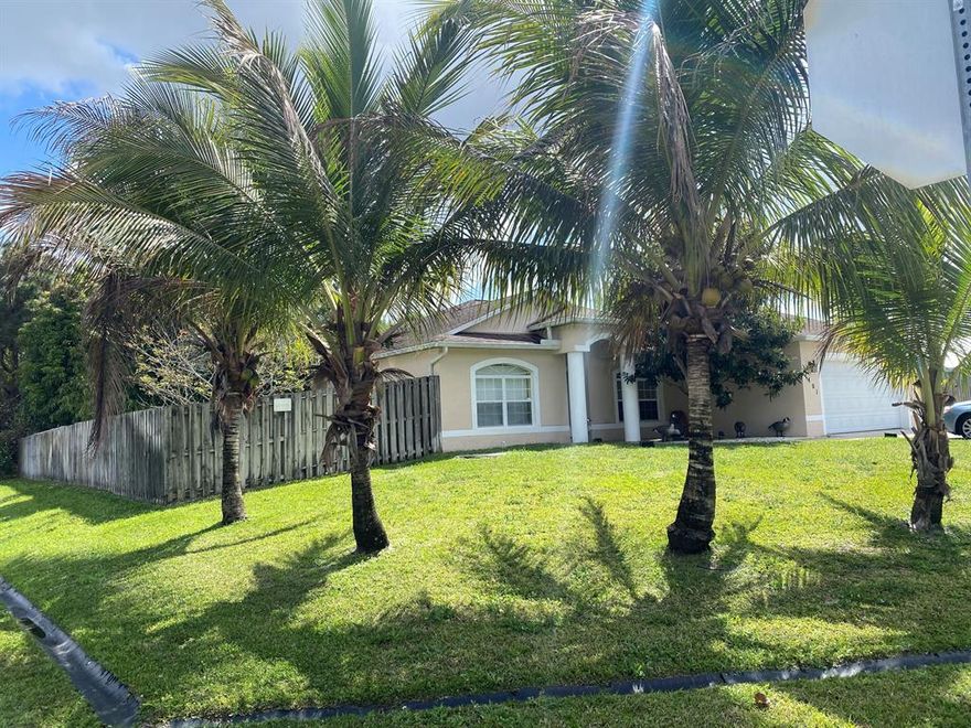 Don't miss this CBS 4 bedroom 2 bath  2 car garage in the SW section of Port Saint Lucie on a superbly landscaped oversized corner lot with mature fruit trees. Home is located within  close proximity to schools and shopping with convenient access to major highways. Granite kitchen counters / Bar with black appliances. Enormous screened patio with summer kitchen & outside shower. Room for a pool and room to add parking for the oversized toys.
