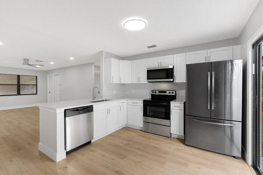 Central Vero Beach location close to the highway, airport, shopping & dining with NO HOA! This beautifully remodeled 2 bedroom, 2 bathroom + oversized 1 car garage home features a modern eat-in kitchen with quartz counter tops, crisp white cabinets, 4 inch quartz backsplash & stainless steel appliances. Freshly painted inside & out with new floors throughout, new baseboards, LED lighting, stylish fixtures & fans in every room. Enjoy remodeled bathrooms with custom finishes. This home is complete with a new roof (2026), AC (2020). Short drive to the beach!