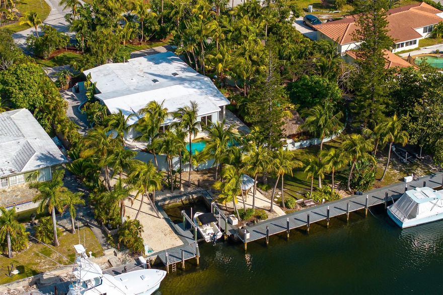 Welcome to The Hibiscus House! This one-of-a-kind Pompano retreat sits on a rare 30,000 sq ft lot surrounded by lush, tropical landscaping reminiscent of Costa Rica. This 4-bed, 4-bath oasis features 3 tiki huts, a pond with waterfall, pool, jacuzzi, and mature trees creating a private paradise. Boaters will love the 150-ft dock with boat lift on a deep canal--just 8 minutes to the ocean. Elevated property with impact windows, travertine floors, and a renovated kitchen overlooking the exotic grounds. A true South Florida gem!