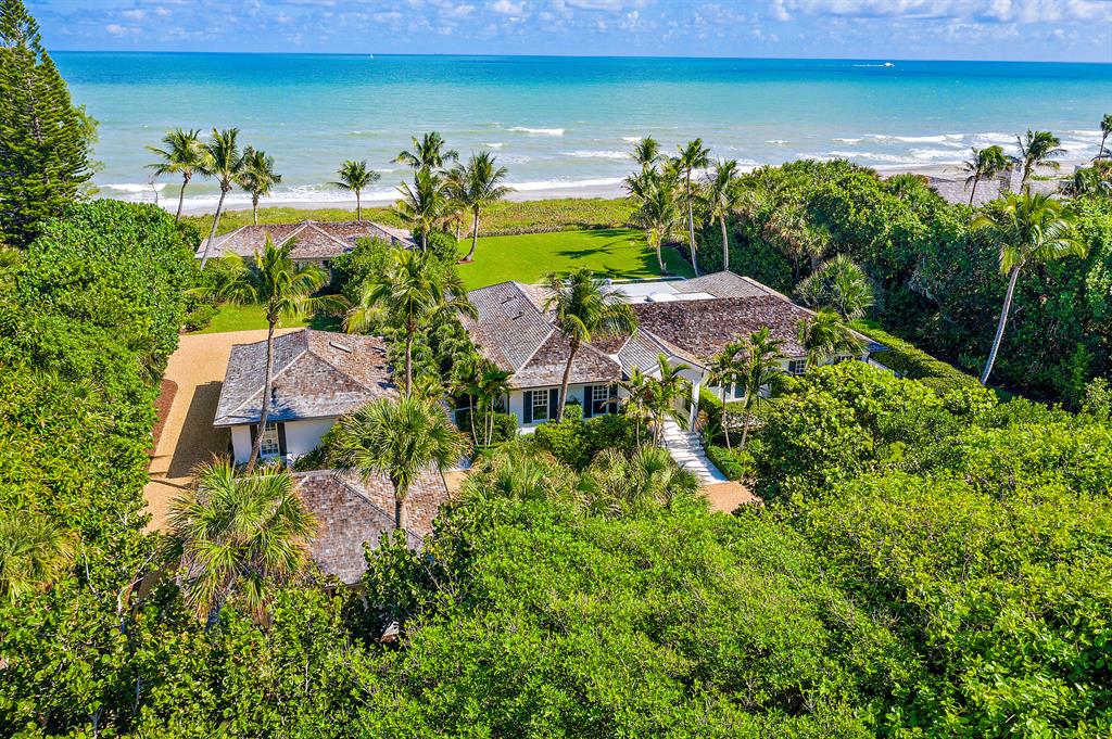This fabulous 1.53 acre oceanfront property with a high elevation sits directly on 200' of prime Jupiter Island beach. In addition to the main house, there are two guest houses each with two bedrooms and baths, separate kitchens and living rooms which can easily accommodate a large family and guests while allowing complete privacy for all. Redesigned and renovated in 2017 to feature a desirable open plan, this family compound includes a beautiful pool area with ample space to swim, dine and sun bathe. If you prefer to relax in the shade, there is a louvered pergola controlled by remote. An outdoor kitchen for alfresco entertaining includes a gas grill, cook top, refrigerator and sink completes this tropical oasis. Please note some photos are virtually staged.