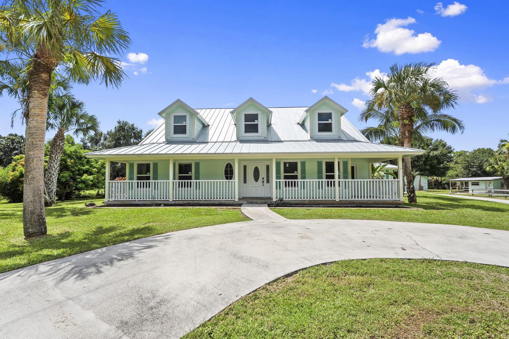 Discover the perfect blend of country charm and modern comfort in this Palm City Farms pool home on 4.6 fully fenced acres. This spacious 4 bedroom, 2.5 bath farmhouse features anew metal roof, impact doors and windows, and two new ac units for year round comfort. The updated master bath offers a fresh spa like retreat, while the inviting kitchen and living spaces are perfect for gatherings. Step outside to enjoy a sparkling enclosed pool and spa, a 4-stall barn ideal for horses and storage, and a scenic pond that adds to the property's serene settings. Plenty of room for livestock, gardening, or just enjoying the peace and privacy of country living.