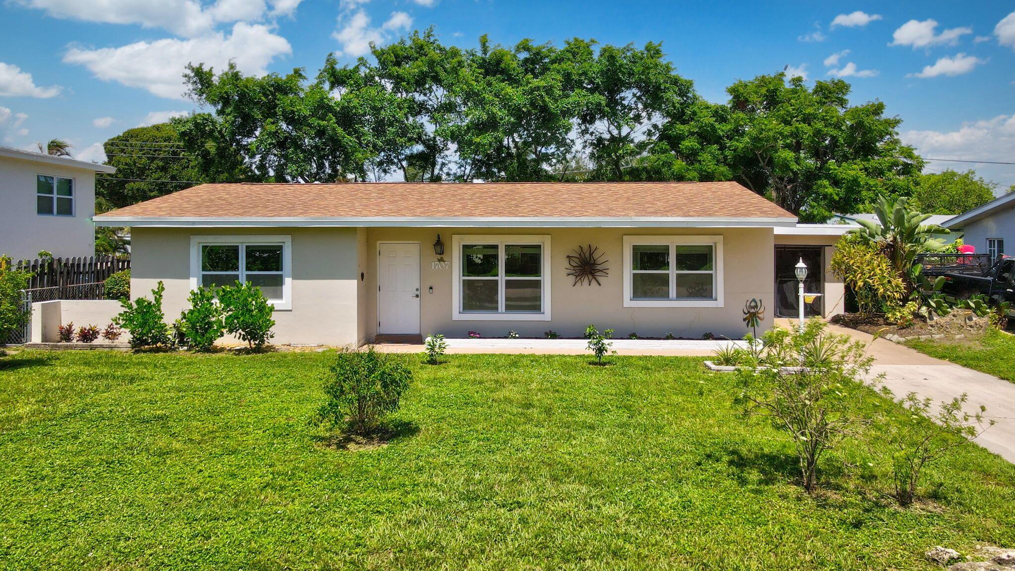 Welcome to this fully renovated gem just steps from the beautiful Lake Osborne, minutes to the ocean, and with easy access to I-95--offering an unbeatable location for both relaxation and convenience. Best of all, No HOA--enjoy the freedom to live as you please. This modern farmhouse-style home has been thoughtfully updated throughout, featuring a newer roof, full-impact windows and doors, and fresh interior and exterior paint. Inside, you'll find a designer kitchen with elegant calcite countertops, modern cabinetry, and sleek ceramic flooring that flows seamlessly throughout the home. The spacious layout is complemented by tasteful finishes and a warm, inviting atmosphere. Step outside to your own tropical oasis--a lush backyard garden filled with mature banana trees, sour sap, jackfruit,