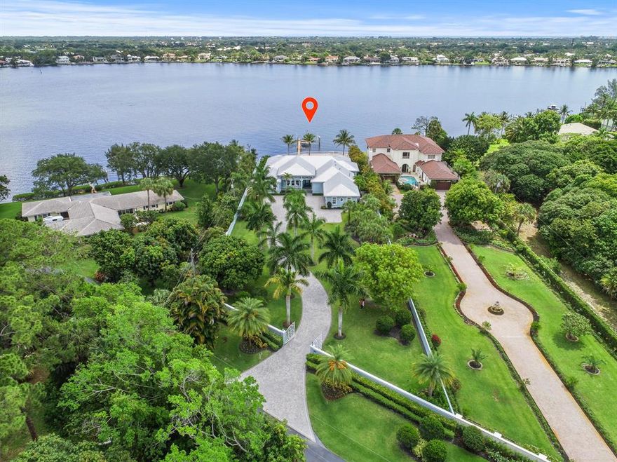 Nestled along the serene waters of the Loxahatchee River lies this beautifully crafted custom home built in 2015 by The Elite Companies on 1.25 acres. This oversized home-site features panoramic views of the Loxahatchee River and is just 5 minutes to Jupiter's waterfront restaurants and the blue waters of the Jupiter Inlet.  Attention to detail was paramount in constructing this concrete block home with hurricane rated impact windows and doors. The architecture is British West Indies with a standing seam metal roof and metal clad and glass hurricane entry doors. Inside you will find fine crafted walnut hardwood floors in the main living areas, custom wood shaker style maple cabinets in the open kitchen, granite countertops with a beveled edge and professional series Thermador...