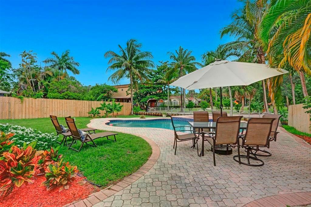 Beautifully updated 3-bedroom, 2-bath pool home is nestled on a quiet canal in the charming Chula Vista/Riverland neighborhood of Fort Lauderdale. Open concept kitchen features sleek quartz countertops, SS appliances, dedicated dining/family & separate living room includes a built in tv screen- a spacious layout perfect for entertaining. The durable laminate flooring runs throughout the home large pantry/laundry room, hurricane impact windows & doors, split bedroom floor plan & the primary suite boasts its own entrance to the lush tropical backyard, Step outside to your private fully fenced oasis featuring paver decking, storage shed, and irrigation. The home sits directly across from the peaceful & secluded Ann Herman Park, offering a tranquil backdrop & added privacy.