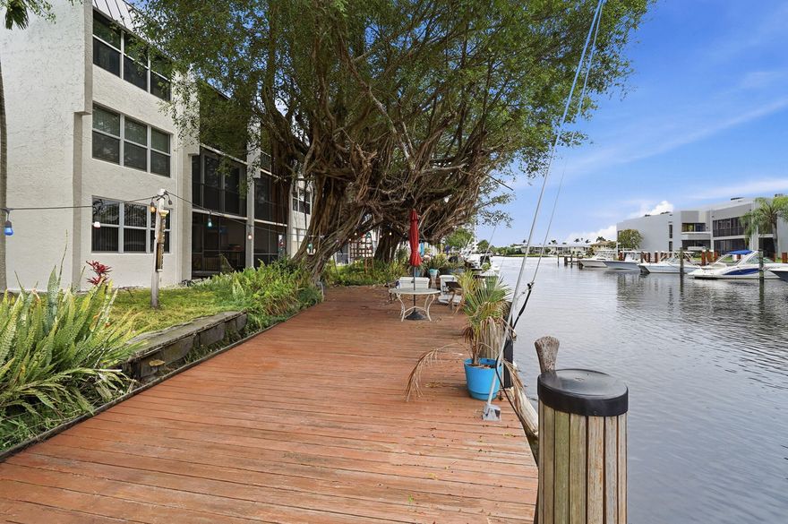 BRING YOUR 40 FOOT BOAT!!! Step inside to an inviting open floor plan filled with natural light, where light wood-style flooring and a ceiling fan create a bright and comfortable living space year-round. The kitchen is thoughtfully designed with stainless steel appliances, crisp white cabinetry, and a stylish backsplash—perfect for both everyday living and entertaining.  Just off the kitchen, the dining area features large windows that bathe the space in sunlight, offering a warm and welcoming setting for meals and gatherings. In addition, the screened porch has been enclosed to allow for additional air condition square footage!  Outside, enjoy your private, oversized assigned dock space which will acomodate a 40' boat. It can be customized to be used as an outdoor living space and barbecue area—ideal for hosting guests or relaxing in the beautiful Florida weather.  Conveniently located near local shops, dining, and the beautiful beaches of Pompano, this condominium offers the perfect blend of comfort, style, and coastal living.