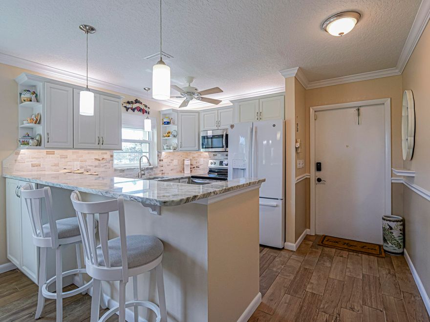 Elegantly updated 2/2 (B Unit) in Vista Royale. Enjoy the serenity of a reflective sunset view over the lake and golf course. Motorized pleated shades and impact windows shield the heat and add to the charm of the cheerful Florida room.  This impeccably stunning home is ready and waiting for you to move in.  Major systems are worry free with a 2022 AC,  newer appliances, granite counters and new cabinetry.

Walking distance to pool, golf club and restaurant.  This community has everything you need from pickleball to shuffleboard.