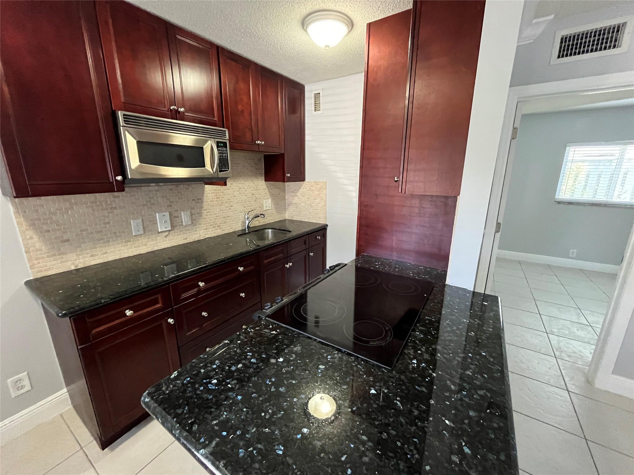 Beautifully remodeled first floor, 1/1 in desirable Poinsettia Landings. Flooring is ceramic tile throughout, Stainless Steel appliances, wood cabinetry, granite and tile in kitchen and bath. End unit. Lush tropical landscaping including heated pool, BBQ area, laundry facility in the building. Pet friendly! Photographs taken prior to current tenant's occupancy. Currently rented until October 11, 2025. Located near Wilton Drive, Downtown Ft. Lauderdale, shopping, restaurants, nightlife, and the beach. The information is deemed to be reliable but is not guaranteed.