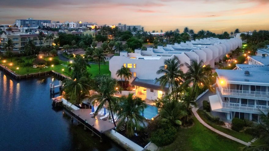 Exquisitely positioned on the coveted Hillsboro Mile, this fully furnished reimagined, coastal residence blends modern sophistication with effortless luxury. Boasting sweeping 180° Intracoastal views from an enviable corner lot, this designer townhome offers nearly 3,000 square feet of impeccably curated living space. Elegant architectural features include a bespoke glass-and-wood staircase, chef's-caliber designer kitchen, custom wine room, indulgent multi-person sauna, ambient electric fireplaces, and a rooftop skylight that invites natural light throughout. Every system is newly upgraded—impact-rated windows, dual-zone A/C, tankless water heaters, Private Elevator & a brand-new roof. Enjoy exceptional amenities including a waterfront pool, Community Dock, & deeded Beach Access. this rare gem seamlessly blends modern elegance with an unbeatable location between the Intracoastal and the Atlantic Ocean.