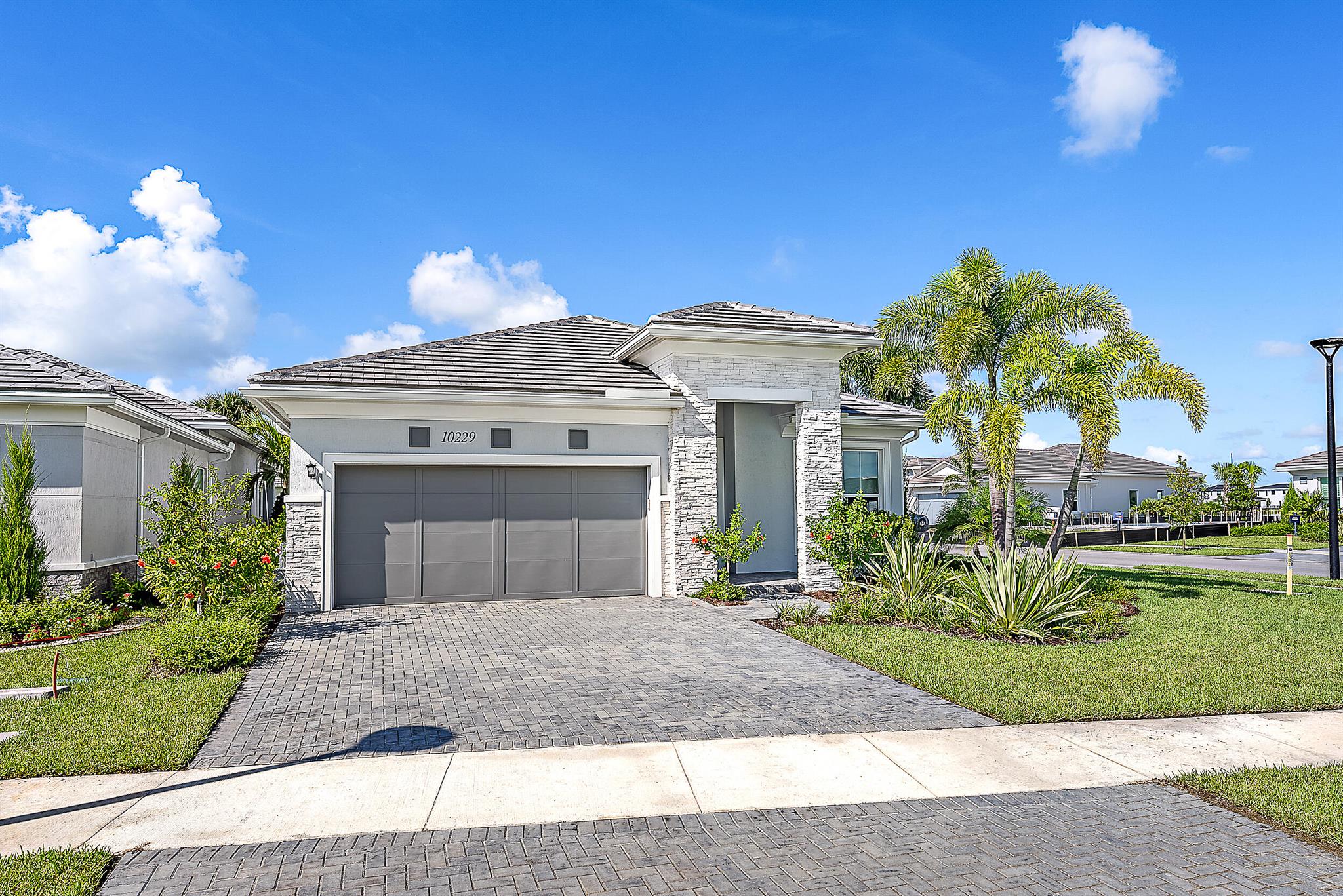 Set on a premium corner lot with lush landscaping and upgraded exterior finishes, this expanded Samantha model blends space, style, and function. The primary bedroom and great room have been enlarged. Den features a lovely bookcase, can be converted into 3rd bedroom. The open layout features tray-ceiling great room and dining areas, a gourmet kitchen with oversized island, professional-grade appliances, and a reach-in pantry. The spa-style primary suite and covered lanai create the perfect indoor-outdoor living experience in Regency at Avenir's resort-style 55+ community.