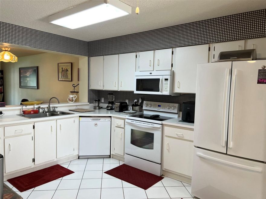 Large Orchid model with ground floor convenience in a charming setting.   Front gate leads to beautiful entranceway.  Private screened front patio. Tiled rear patio has extra closet for added storage space.   Brand new water heater, dishwasher, washer & dryer, main shut off valve and disposal.  New coils in A/C.  Newer refrigerator.  All windows and sliding doors have extra protection from hurricanes.  Both bedrooms have impact windows plus accordion shutters and all 3 patio doors have accordion shutters plus roll down shutters on back patio for additional protection.   All tiled floors except for living room. 3 TV's on walls included.  Enjoy all the Kings Point amenities, including activities in the spacious clubhouse, courtesy buses and the fabulous Palace Theatre.  Assoc. states 55+.
