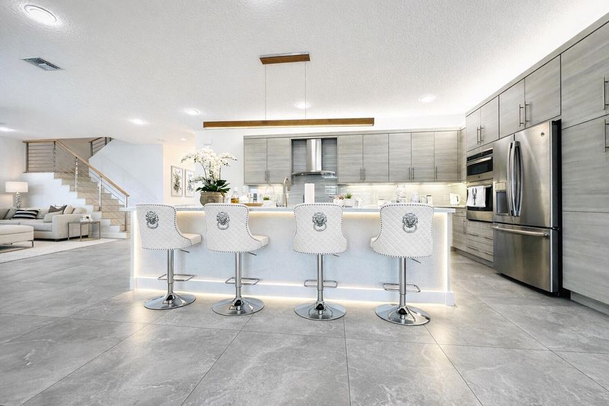 Fully furnished designer home, styled like a model residence and included in the price. Located in Dakota, 15377 Green River Court sits on a prime oversized west-facing lakefront lot with stunning sunset views and added privacy. This Siena Grande model by GL Homes offers 6 bedrooms and 5 full bathrooms with high-end upgrades throughout. Features include Italian tile on all levels, a custom stone staircase, a designer wine wall, and abundant natural light. All bathrooms include custom Italian-style walk-in showers with glass doors. The primary suite offers dual closets and vanities with a spacious shower. Enjoy a private backyard with pool, covered patio, and lake views. Impact windows and 2-car garage. DAKOTA COMMUNITY BY GL HOMES