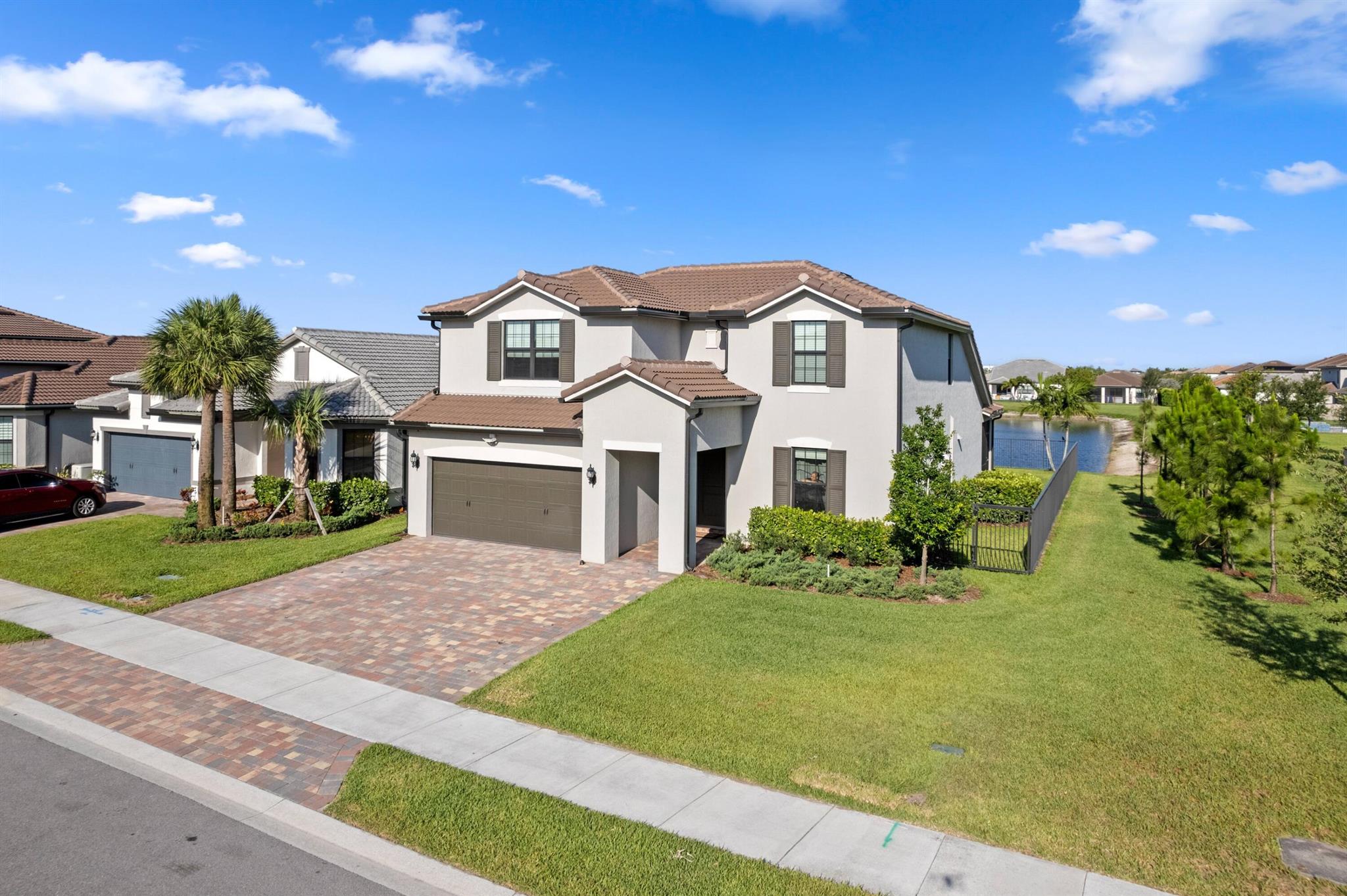Lake views, luxury vibes, and loaded with space- welcome This 5- bed stunner sits on a corner lot with a dreamy water view and a layout built for real life. Primary suite + bonus guest room (or office) downstairs, massive loft upstairs, and a private guest suite with its own bath. Upgraded tile, plush carpet, and a garage so big you'll actually want to organize it. Extended driveway = no parking battles. Built in 2022 with full impact windows and doors and a builder's warranty still in place. This isn't just a house- it's the one!