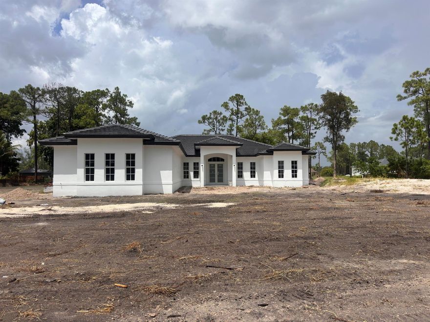 Beautifully designed 5-bedroom, 4-bathroom new construction home located in the heart of Loxahatchee.This stunning property sits on 1.19 acres of land. Sleek wood- look porcelain tiles throughout. Huge kitchen island with ample storage. Custom closets in the primary bedroom. Situated on 1.19 acres of cleared land, this property offers the perfect blend of luxury and space. Estimated to be completed mid October.