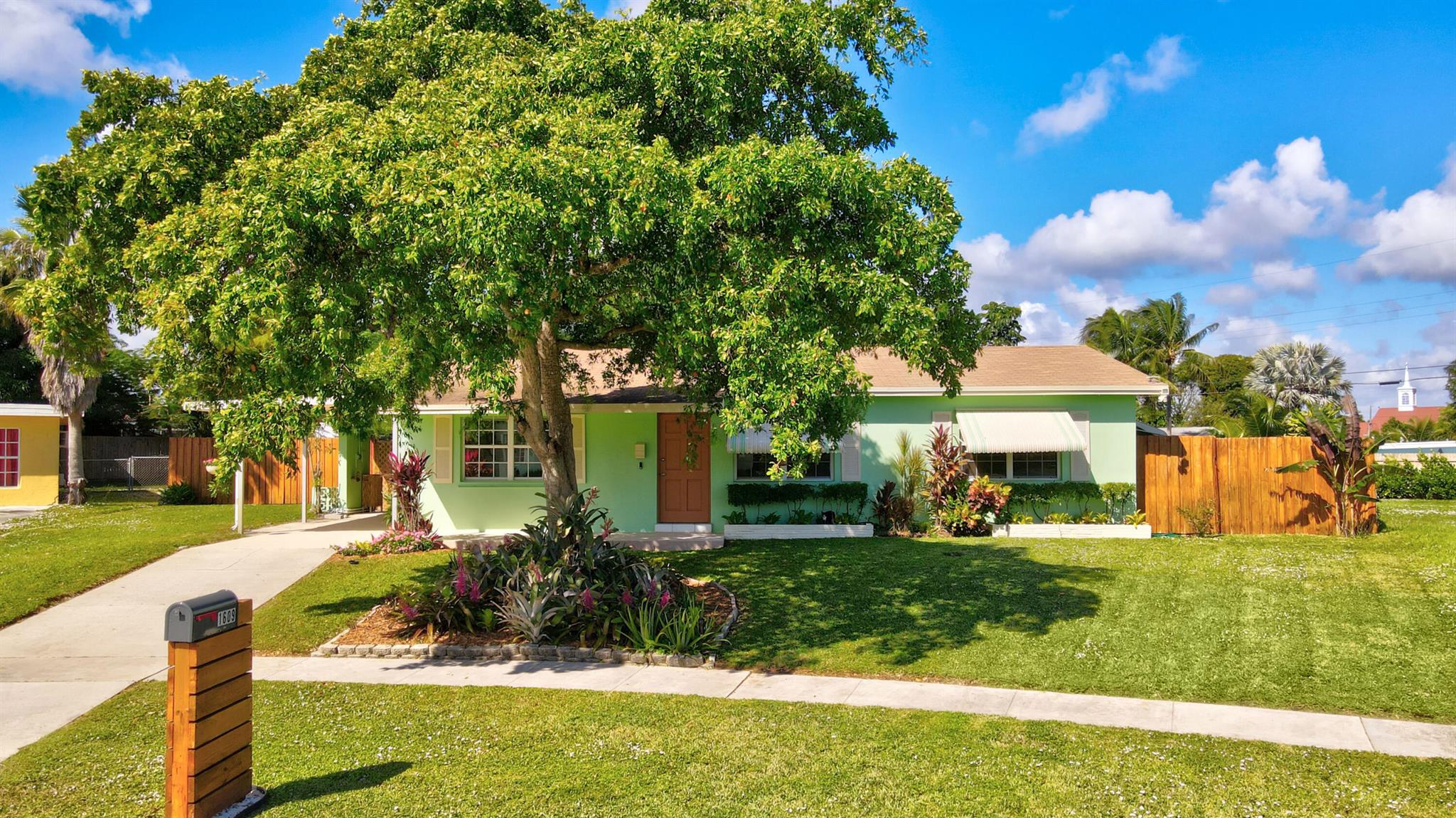 No HOA!!! This tropical oasis is just waiting for you to call it home. 2 1/2 blocks from Lake Osborne. Home has covered area to store your boat. Endless opportunities in this expansive lot, almost 1/2 acre, perfect for entertaining. Fenced yard complete with new 13ft pavered patio. 14x20 wood deck built in 2020. Make smoothies from your fruit trees or warm up on chilly nights with your fire pit or outdoor fireplace. The open floor plan boasts terrazzo, ceramic and wood flooring. The bonus room with stone fireplace has endless possibilities. Upgraded gas appliances, pot filler, granite countertops, whole house water filter system, separate laundry room with storage. Freshly painted inside and out. Updated bathrooms. Located minutes to Costco, I95, restaurants and shopping, 10 min to beach!