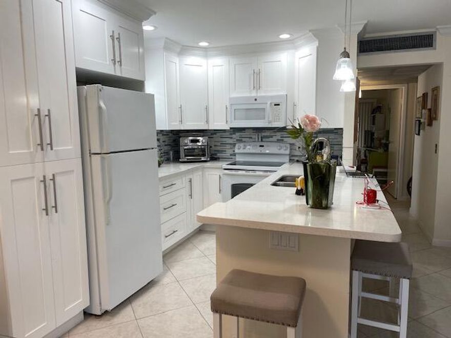 Beautifully updated Open Concept Kitchen,  bright, tiled flooring, renovated bathrooms, enclosed porch, ready for you to enjoy the beautiful pools, Club house with  state of the art theater with live shows, Cafeteria, Gym, Dancing,  Golf Course, Tennis, a Bistro, courtesy buses for shopping and much more.. close to restaurants and the beautiful Delray beach.