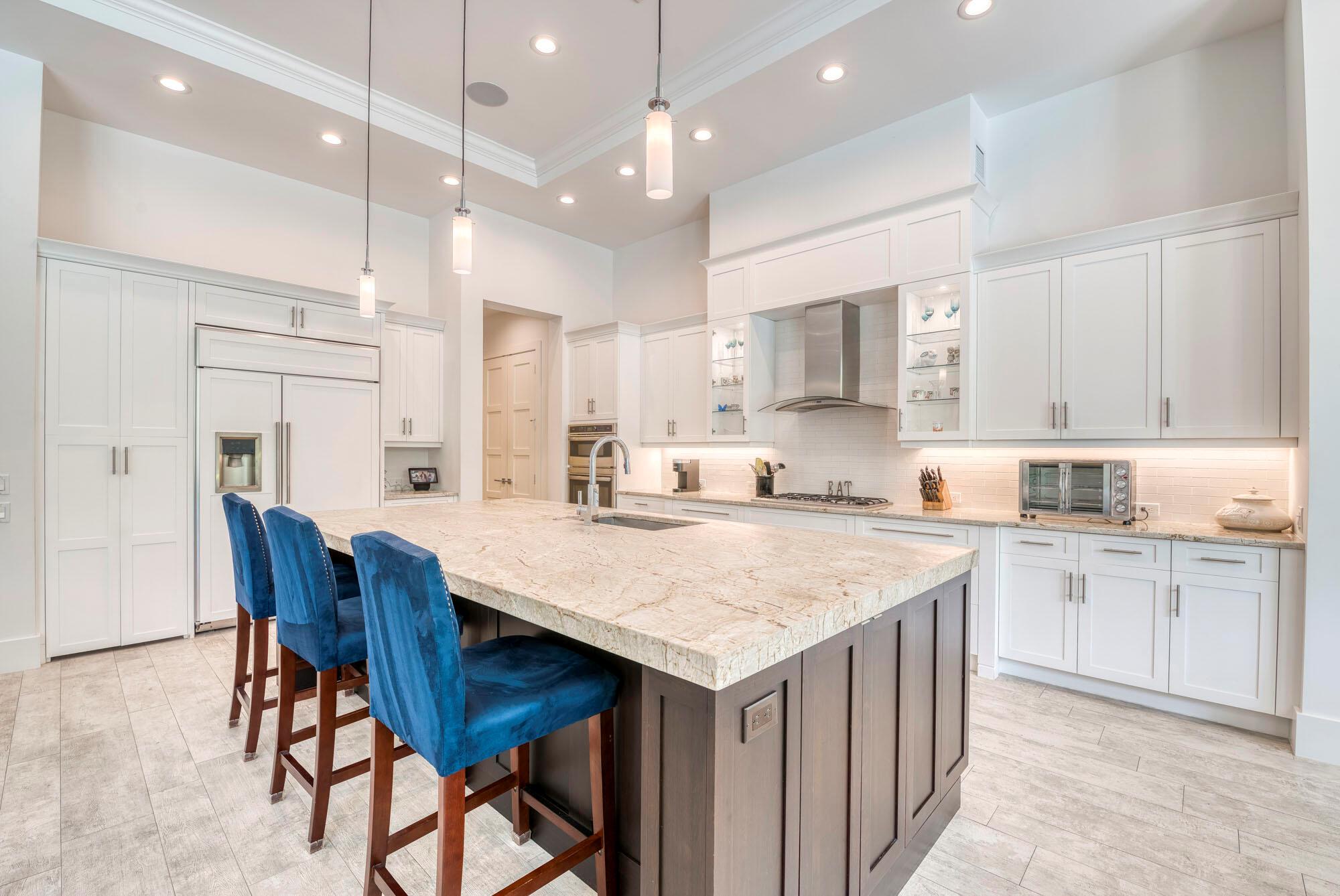 Welcome to this stunning custom-built, 4 Bed/4.1 Bath + large office/den, home by Puzzitiello Builders. A true embodiment of modern design and sophistication. This Florida Power & Light ''Build Smart'' energy-efficient home features a new look flat tile roof, tankless hot water heater and 2 energy efficient A/C units. Step inside to discover an open concept floor plan, creating an inviting and airy atmosphere throughout. Indulge in the elegance of the sophisticated dining room, boasting a spacious layout with pristine white walls accentuated by a captivating blue accent wall. The pristine white kitchen is a culinary dream, showcasing top-of-the-line stainless steel GE Monogram appliances, exquisite quartzite countertops, and an oversized dark wood-accented island. The concealed walk-in