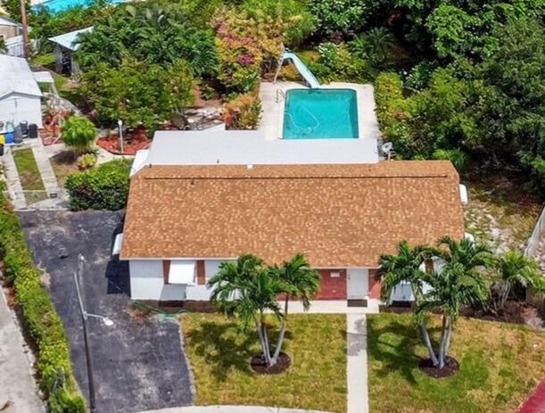 Discover this gem- an original-owner, NON-HOA pool home with a fully fenced 1/3-acre lot in the charming coastal town of Lantana! This 3BD/2BA split-plan home offers 1,800 sq ft under air, a new roof (June 2025), 2021 A/C, and 2019 pool pump. The backyard is a tropical oasis with whimsical paths, shaded deck, and large pool with slide-perfect for entertaining! Inside features include large bedrooms, a spacious guest bath, separate family, living, and dining rooms, built-in shelving, indoor laundry, and a roomy kitchen with pantry and storage. Oversized driveway fits 5+ cars plus RV/boat parking. Detached shed w/wall A/C is ideal as workshop, + separate greenhouse & outdoor storage shed. Fresh sod in front 7/25. Walk/bike to intracoastal, beach, shops & dining. Jump on 95! Ideal location!
