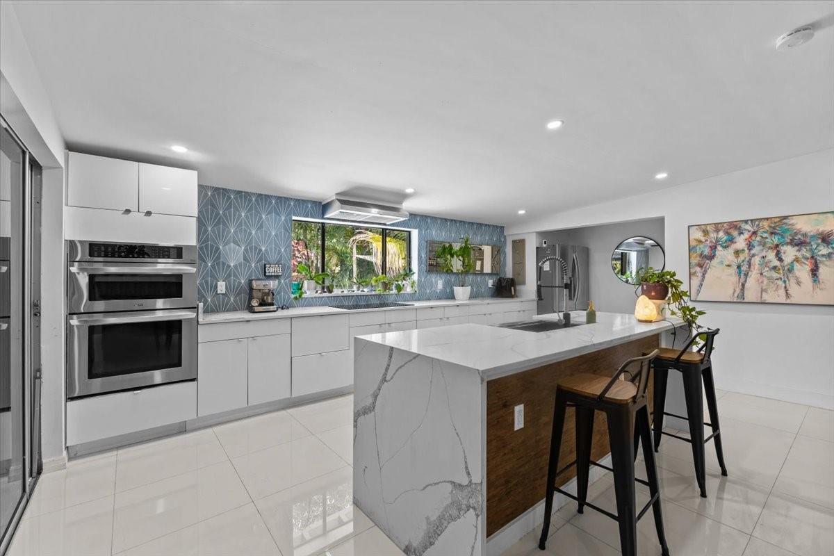 Just minutes from the heart of Wilton Manors, this beautifully upgraded 3-bedroom, 2-bathroom home features sleek 24" porcelain tile and a modern kitchen with a waterfall island and sink—perfect for entertaining. Relax year-round in the oversized enclosed patio or step out to your private backyard oasis with a sparkling pool beside a serene waterfall. Additional highlights include accordion shutters for storm protection, a large laundry/storage room, and a one-car garage.