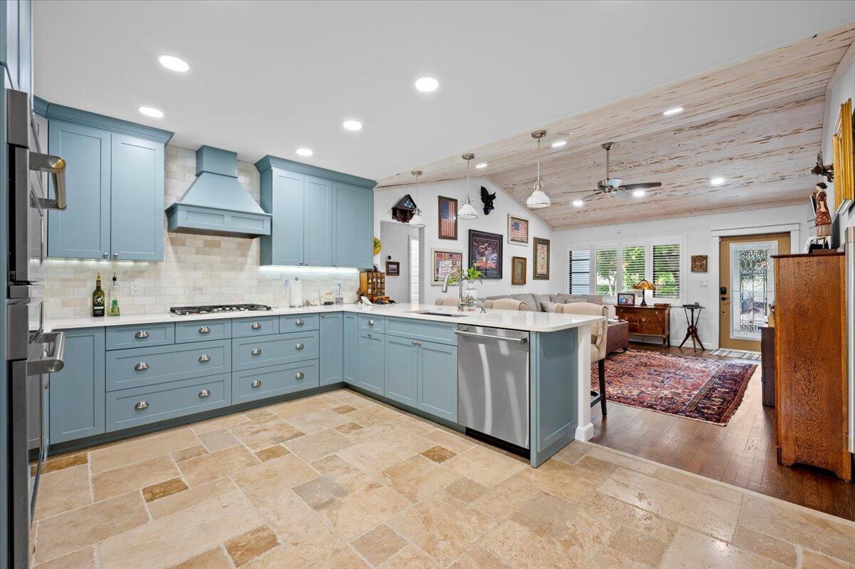 Updated CBS home featuring Travertine flrs, hardwood floors, pecky cypress vaulted ceiling in Living Room, Herringbone design wood ceiling in Dining Rm, Gourmet Top Of The Line Kitchen w/quartz counters, tumbled marble backsplash, s/s GE Monogram appliances which includes custom blt in Monogram Fridge w/wood panel exterior, soft close cstm kitchen cabinets w/undermount lighting & gas cooktop w/vent, all impact wdws & doors throughout w/cstm black trim, 2 bedrooms + a den/office/laundry/possible 3rd bd w/plumbing for a 2nd bth, beautiful cstm Full Bath w/vessel sink, cstm unique vanity & mirror, tumbled marble fl in shower tiled w/mother of pearl custom tile , fenced in yard, tankless h/w/h, 3 blocks to intracoastal, turn key home in a great neighborhood!