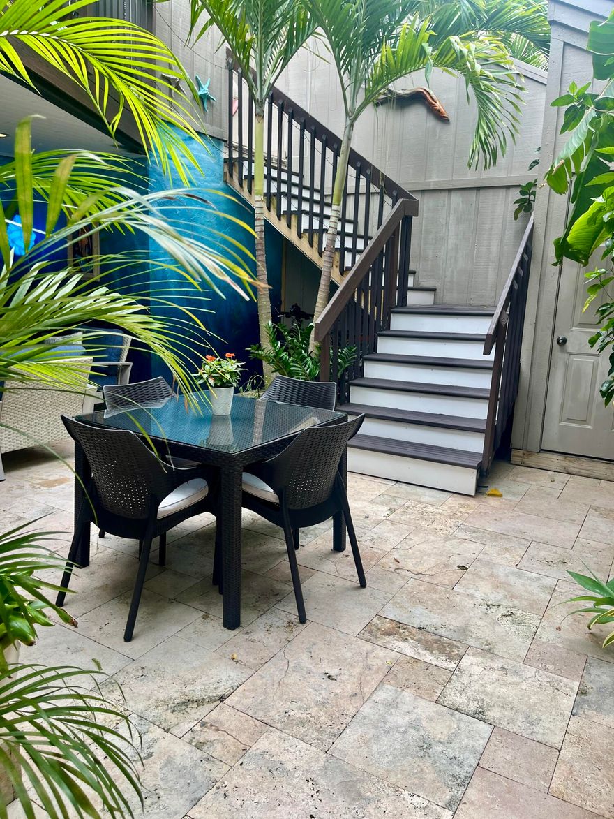 Rare opportunity to own a bright and private end-unit townhome in the highly desirable Sea Lofters community of Jupiter Ocean & Racquet Club—just a 3/10 of a mile walk to Jupiter's turquoise beaches, Carlin Park, Harbourside, dining, shopping, and the Maltz Jupiter Theatre. One of the few developments where monthly rentals are approved. You can enjoy your home part of peak season and earn rental income part of peak season!    This light-filled residence features soaring ceilings and a dramatic wall of windows, creating an open, airy living space that captures the essence of coastal living. The thoughtfully designed layout offers a seamless indoor-outdoor flow, ideal for both everyday living and entertaining. A standout feature is the two-level private courtyard, beautifully upgraded with travertine flooring on the first level and Trek decking on the upper level and stairs. The custom outdoor kitchen with grill and refrigerator creates the perfect setting for al-fresco dining, while the outdoor shower adds convenience after a day at the beach.  The lofted primary suite overlooks lush tropical landscaping, offering a peaceful and private retreat. As an end unit, the home enjoys added privacy and abundant natural light throughout.  Located in Jupiter Ocean & Racquet Club, residents enjoy a true walk-to-beach lifestyle along with exceptional rental flexibility—30-day rentals permitted up to 12 times per year—making this property ideal for seasonal use, investment potential, or full-time coastal living.    Recent Updates Include: Cat 5 impact windows, outdoor kitchen (2023), outdoor shower (2023), AC compressor (2023), kitchen range (2021), garbage disposal (2021), underground irrigation system with rain sensor (2023), and landscape up lighting with remote controls (2023). New Roof in 2016. Note: Wall art throughout the bi-level courtyard and home does not convey.