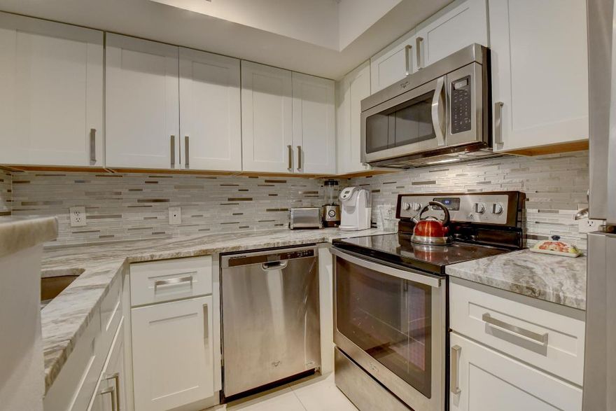 I hope you have your plane ticket ready & in hand because a unit like this rarely if ever hits the market.A stunning 2 bed 2.5 bath townhouse w/impeccable renovations & nothing overlooked.Enter your vacation oasis with modern tile floors, neutral paint colors, remodeled kitchen, baths and even down to the PVC pipes which were changed to copper throughout. All appliances, water heater and  a.c. unit are all newer and have tons of life left for your enjoyment.The wood staircase leads to your spa like primary bath flanked in marble and granite.Plenty of storage w/walk in closet & large Primary bedroom.Both bedrooms overlook the expansive greenspace & second pool.Your private sanctuary awaits as there is nothing to do or bring except yourself.Gated & secure,the Yacht Club is now your new home.