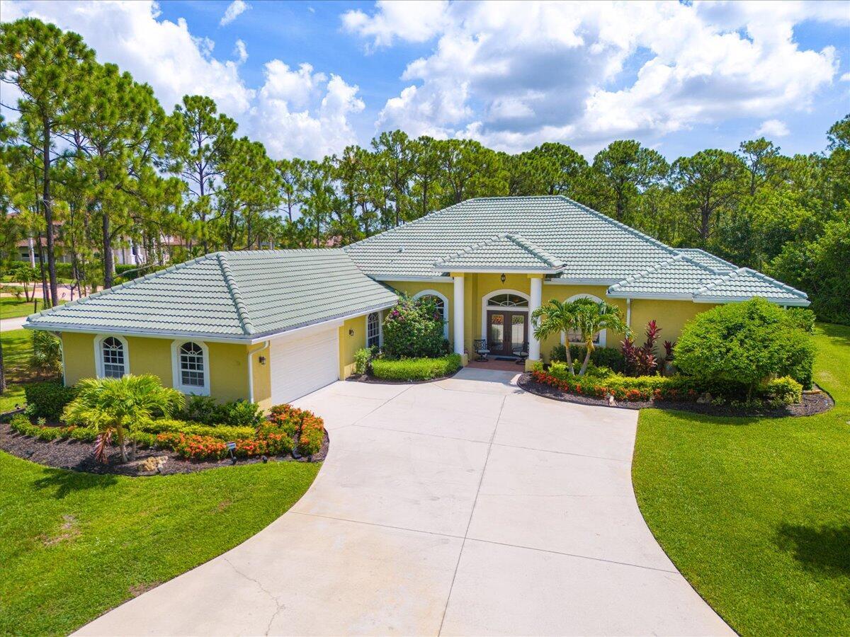 Fabulous Estate Property in Sabal Creek at PGA Village on 1.72 Corner lot. Features New Barrel tile roof 2024, CBS Construction, 4 BR's, 4 BA's, Office, LG Bonus Room & 2 Car Garage. Details include Stunning New Porcelain flooring in main areas & 2 Baths in 2024, split floor plan offers formal living room, dining room, wet bar area & spacious family room. Updated eat in kitchen include 42'' cabinets, granite counter tops, breakfast bar & walk in pantry. Volume ceilings, Plantation Shutters, 2 A/C's (Main house updated 2024). Grand Master Suite, Renovated Master Bath 2018 include Roman tub, shower & dual sinks. Wonderful picture window screen enclosed heated pool/spa with large covered area & private tropical setting. Re-surface pool deck & new pool pump -2024. Upgraded sprinkler on well.