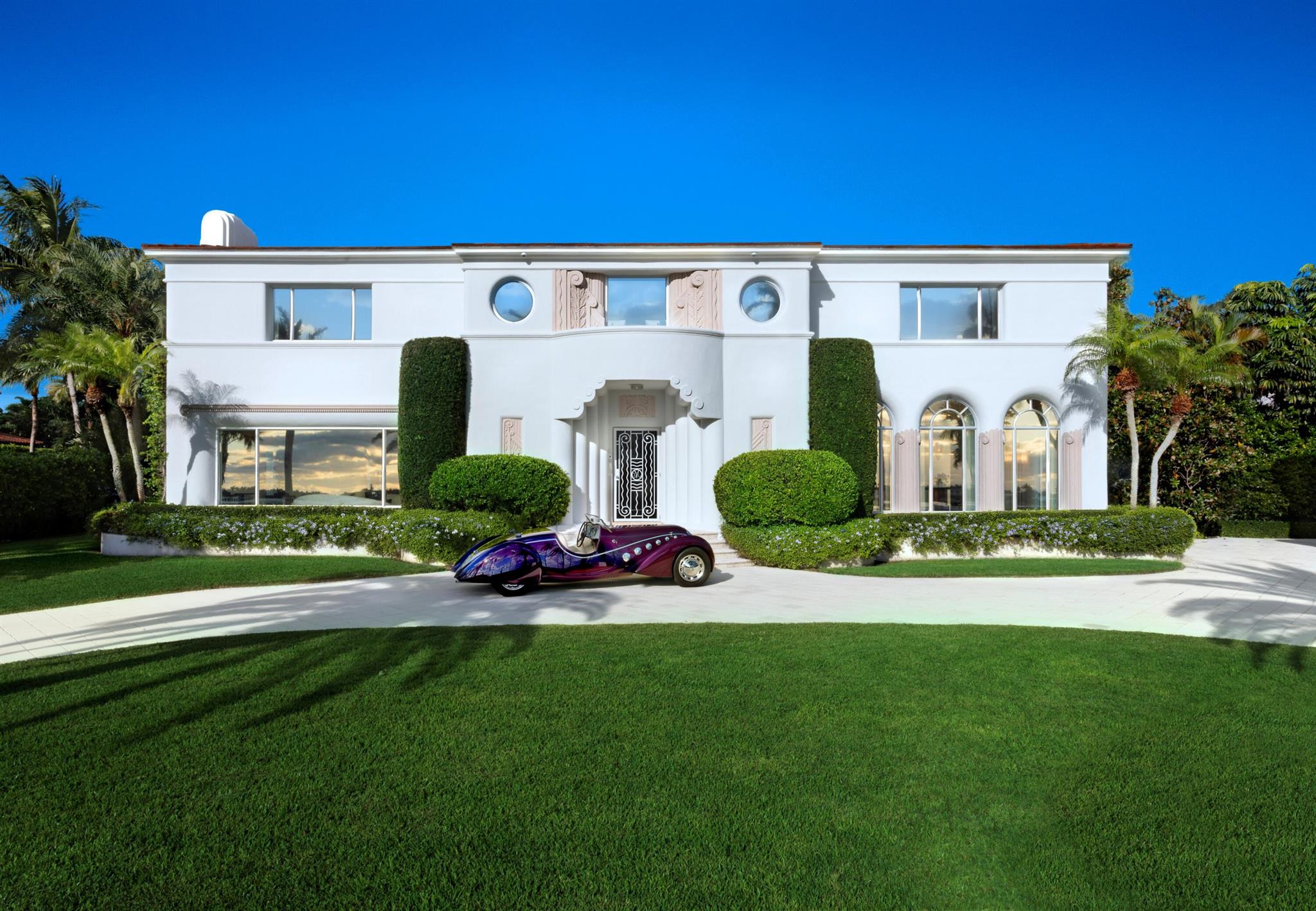On the West Palm Beach waterfront this 1937 Belford Shoumate iconic architectural legacy beautifully bridges its nautical moderne heritage with today's modern luxury. Thoughtfully and comprehensively updated, the home retains its signature period details- including sea-foam green terrazzo floors, wavy ironwork banisters, a graceful circular staircase crowned by a domed ceiling frieze, and a curved fireplace-all blending historic artistry with contemporary sophistication. Steamship-inspired railings, a blue-tile-lined pool, and a scrolled stucco banister leading to a side entry complete the picturesque waterfront setting. Featuring 6 BR, 7.1 Ba, elevator, 3-car garage, and outdoor kitchen, this landmark property spans 23,836+/- SF of magnificence along the Intracoastal.