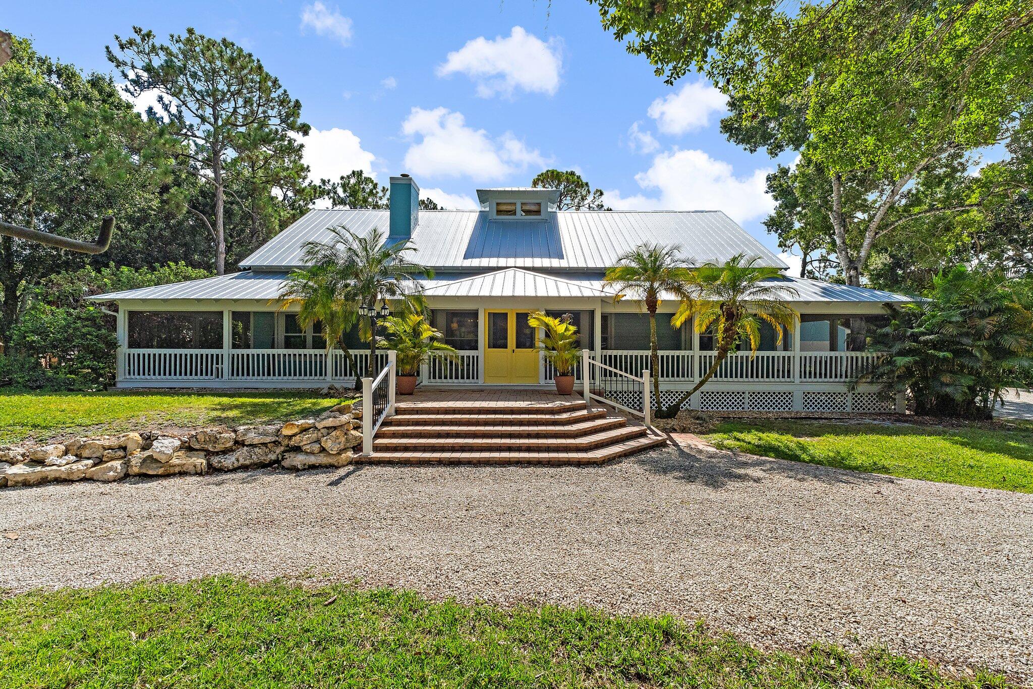 1.25 acres in Jupiter Farms with no HOA, a 2025 metal roof, and full impact windows. This move-in-ready property delivers the freedom of laid-back acreage living with room to grow, all just minutes from Jupiter's top schools, parks, and beaches.Inside, this two-story home offers an inviting blend of open-concept living and loft-style charm. The main level features a bright and airy great room with vaulted ceilings, a spacious kitchen with two islands, the private primary suite with a full en suite bath and generous closet space, plus two additional bedrooms and a full guest bath. Upstairs, the open loft overlooks the living space and leads to a fourth bedroom, while an unfinished attic offers bonus potential, perfect for a tucked-away retreat, creative studio, or home office.Step