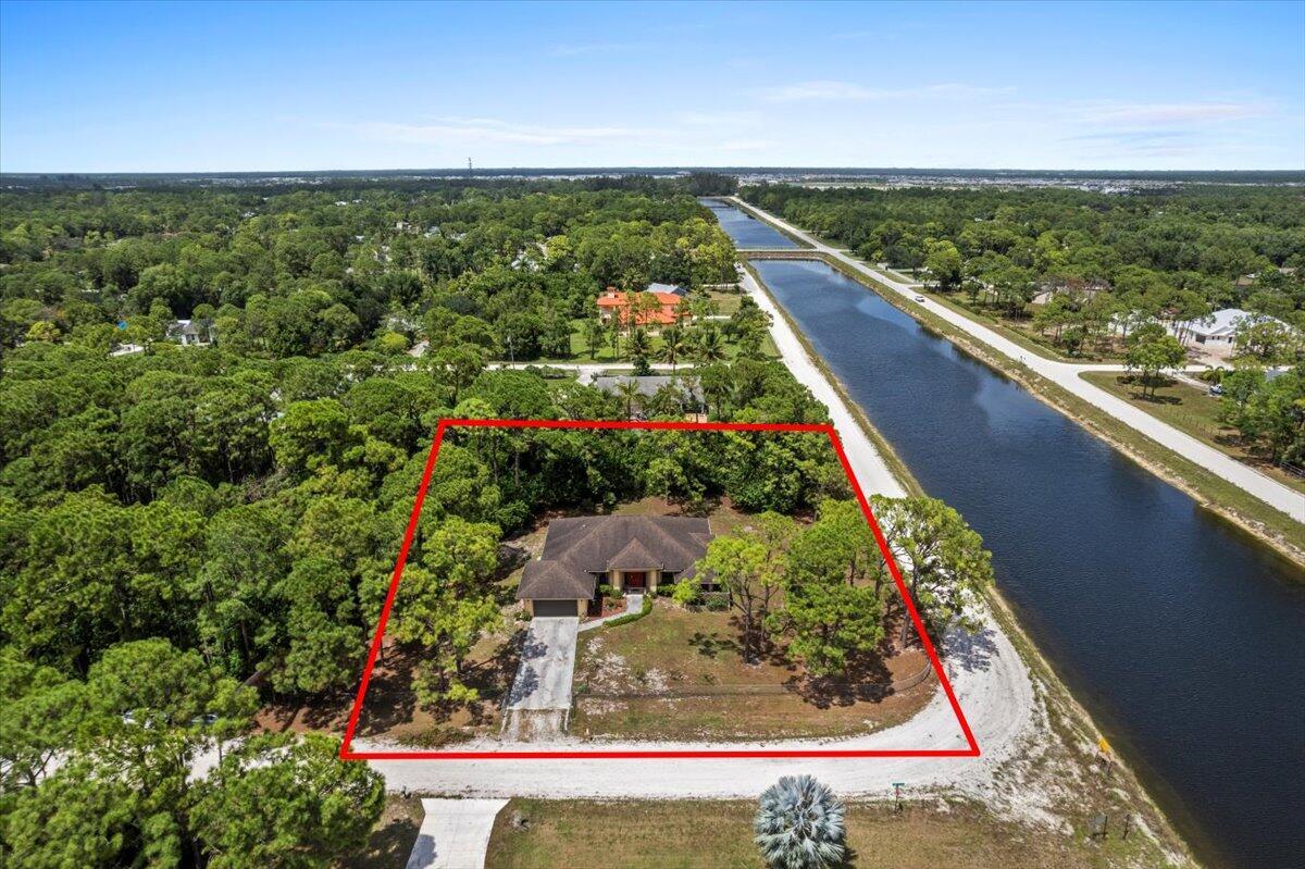 Spacious 4BR/2BA home with nearly 2,500 sq. ft. under air on 2.19 secluded acres adjacent to a canal waterway. Enjoy complete privacy on this corner lot with no HOA. Features include vaulted ceilings, split floor plan, large master suite with sliding doors to a huge 400 sq. ft. screened patio, and accordion shutters for full hurricane protection. The home offers a formal living and dining room, breakfast nook, family room, and a large open kitchen. Exterior is finished with durable Hardie board siding and a 2-car garage. Priced to sell--this private retreat won't last long!