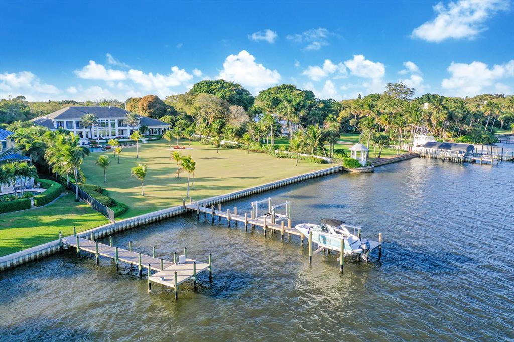 This magnificent St. Lucie River estate rests majestically on 2.4 Acres. This spectacular 5BR home was designed, custom built and finished in 2017 with the utmost attention to function, flow and fun. 205 ft. NEW seawall and 60ft. dock w/lifts. Panoramic views of the River, Intracoastal and Inlet from outdoor entertaining areas and most indoor rooms. Seamless, elegant plan is complemented by Fitness and Trackman simulator room, his and her offices, Pub with 1144 bottle wine cellar, custom kitchen with superior grade appliances and 5-bedroom suites. Spacious rooms flow impeccably with beautiful limestone and French oak floors. At times it can be difficult to enjoy the exquisite interior when the spacious outdoor kitchen and loggia welcome you to lagoon waterfall pool, firepit and tiki hut.