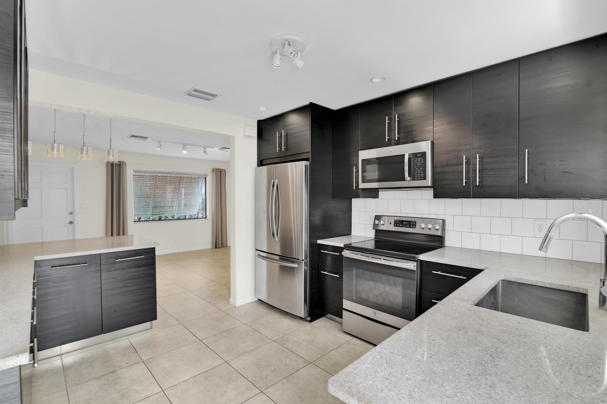 WOW! Updated, affordable, and peaceful. Welcome to a rare opportunity to live in this charming duplex in the heart of Delray Beach! Nestled in the highly coveted Pineapple Grove District. Just steps from the vibrant Atlantic Avenue and a quick ride to Delray's award-winning beaches, you'll love the walkability to world-class restaurants, boutique shops, art galleries, and lively nightlife. This beautifully renovated 2-bedroom, 1-bath home offers the perfect combination of charm and modern comfort. The kitchen offers sleek upgrades with stainless steel appliances and custom black, glass cabinetry. The primary bedroom includes additional space that can be used as a home office, reading nook, or guest area flexible to suit your needs.