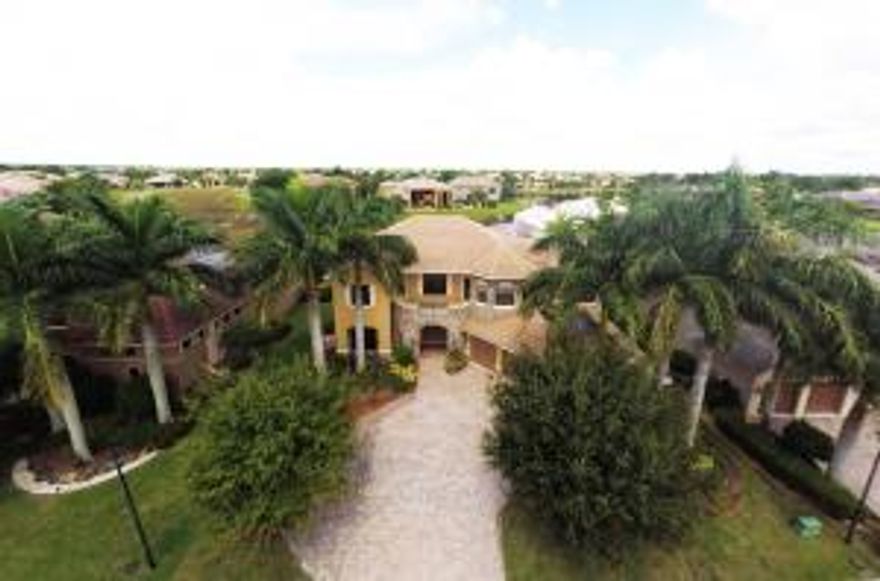 Outstanding value for this spacious and bright two story home on lake in Wellington's most popular community: Versailles. Stunning views to appeal to a naturalist, with intriguing wildlife and abundant lake view. 3 fruit trees are featured, plus an herb garden. The interior boasts marble and wood floors and carpeting upstairs. A n enormous master suite has 3 large closets and a luxurious marble bath. A spacious balcony overlooking the pool and lake adjoins the master BR. Downstairs offers guest suite opening to pool area and office. Designer kitchen and butler's pantry enhance the entertainment factor, as well as a screened in outdoor dining area. 80% of the interior has crown molding to enhance the design appeal and all window treatments and fixtures remain. For storm protection, accordion shutters throughout and impact glass in the front. This beautiful home has many extras and is perfect for the buyer who needs a layout with many bedrooms.  Great school zone, close to freeways, airport, shopping and entertainment. A great value for everyone.