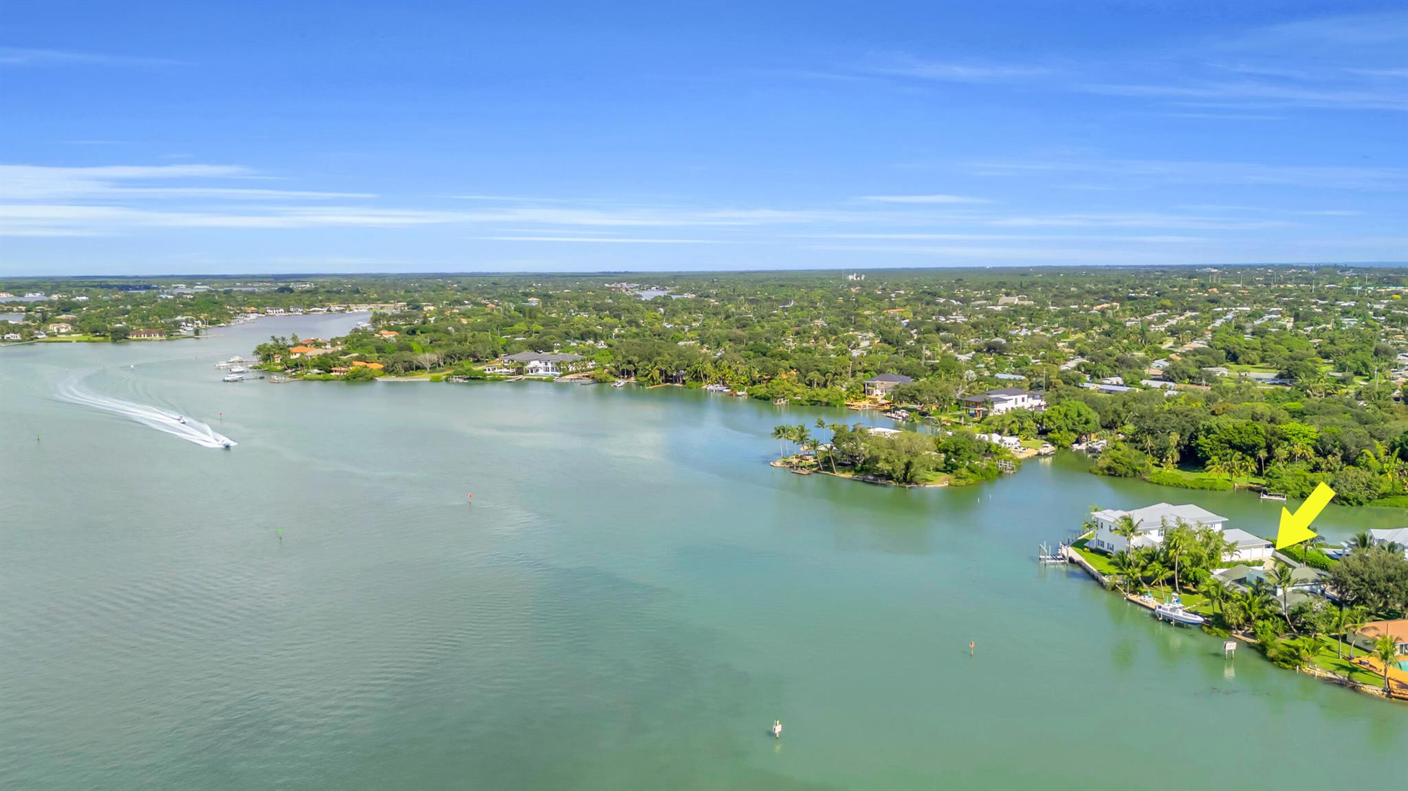 Big Water Hidden Paradise!  ~115' of Riverfront tucked away just south off Riverside.  Old Florida Entrance to (4) residences located on the point of Peninsular. This home is move in ready.  Take your time and decide what renovations or new floor plan takes best advantage of panoramic river views.  Built in 1976, this home's interior is charming.  En Suite Bedroom on main floor.  Primary Suite on 2nd floor with 3rd bedroom.  2 Car Garage has a FULL BATH and Kitchenette in case you need a guest quarters.  See Floor Plans in Documents. Fenced Yard w/Multiple Palm Trees.  Roof 2003 Comp Shingle.  Dock is 2008 with a lift holding a 35' Contender.  Seawall w/ Cap.