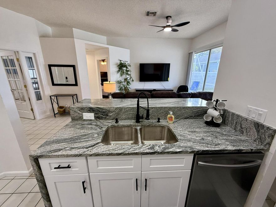 Updated 3BR/2BA home with 2-car garage, fenced backyard. Enjoy indoor-outdoor living with sliding glass doors from both the family room and primary suite leading to a screened patio. Remodeled kitchen features new cabinets, stainless steel appliances, granite countertops, bar seating with waterfall edge. Spacious primary bedroom is furnished with a king bed and includes an ensuite bath with dual granite vanities, LED mirrors, and large walk-in closet. Second bedroom includes a queen bed and large closet. Third bedroom is set up as an office with a queen leather sofa (queen sleeper bed). Comfortable family room offers reclining sofa and massage chair. Screened patio includes outdoor table and seating. Move-in ready and fully furnished, turnkey! Available now OFF Season until November.