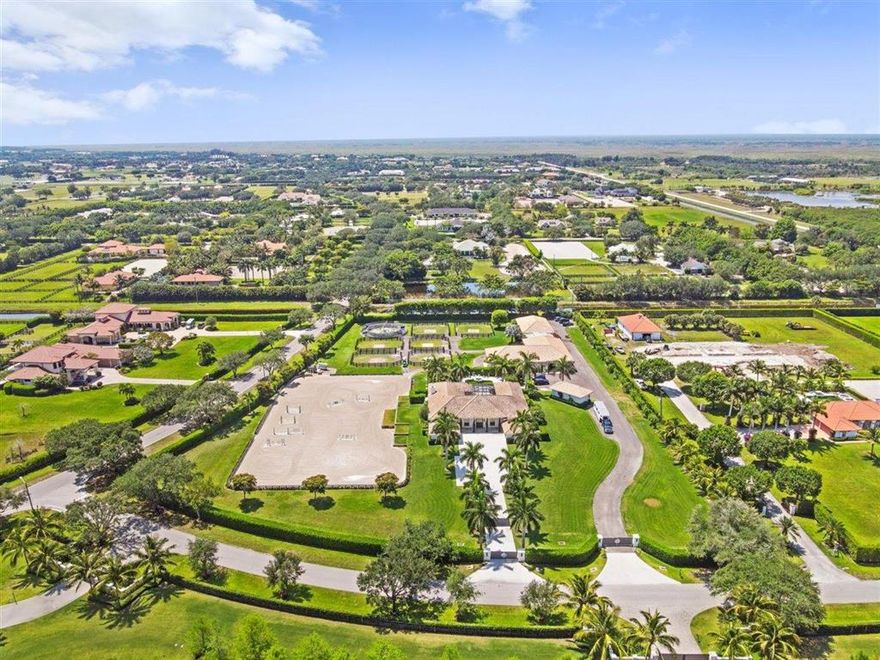 Striking 5.7 acre equestrian estate in sought after Palm Beach Point only minutes to all horse show venues. The main residence has gone through an extensive custom renovation with open floor plan, exquisite finishes, and high end appliances. The large screened center patio with full Florida kitchen overlooks the large salt water pool and lanai. Just beyond is the recently constructed 14 stall barn. No expense spared in the design and construction of this equestrians dream facility. Beautiful tack room, office, lounge, laundry & storage room with every amenity. The 150 x 265 ft riding arena is adjacent to the 6 paddocks and walker. There are 2 apartments (1 & 2 bedrooms) with high end finishes and 2 kitchens. The property is accessed through 2 separate gated entrances. There is a whole property generator. Truly a MUST SEE PROPERTY!!