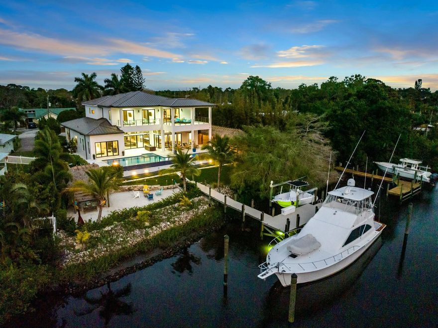 Discover luxury living at its finest in this exquisite 2022 custom-built modern home. Situated on nearly half an acre, this property offers ocean access and a private dock that accommodates yachts up to 60' on 121 feet of water frontage, making it a boater's paradise. Boasting a versatile layout, the home features four, possible five bedrooms plus an office and loft. Adorned with premium marble flooring throughout, creating a sleek and timeless aesthetic. The centerpiece of the gourmet kitchen is an illuminated waterfall marble island, complemented by top-of-the-line Thermador appliances for a chef-inspired experience. Enjoy the Florida lifestyle and tropical feel with a private beach equipped with your own tiki bar and heated 60x18 infinity pool overlooking the river.