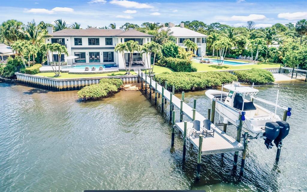 Spectacular newer construction custom home with 128' on the Loxahatchee River featuring beautiful and panoramic water views! This expansive 8,950 total sf house is situated on a large .75 acre lot and truly showcases the best of everything! Only the finest of craftsmanship and materials were used by renowned custom home builder, Turtle Beach Construction. There are 5 bedrooms, the spacious and luxurious master suite on the first floor has enormous his and hers closets and exceptional river views! The gourmet island kitchen has chic concrete counter tops, top of the line appliances and cool contemporary cabinets and it opens up to the main living area and spectacular covered patio, resort style pool, and summer kitchen with outdoor bar! Other features include all impact windows and doors,
