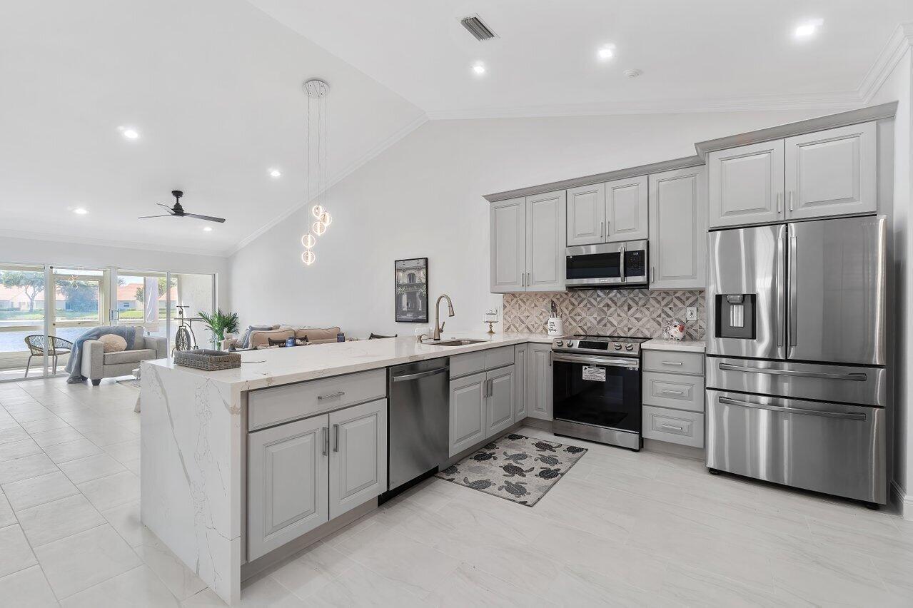 Remodeled waterfront unit in vibrant 55+ Delray community. Freshly painted, porcelain flooring, Grey wood shaker cabinetry, Quartz countertops, French doors, beautiful designer details. ROOF AND ROOF MAINTENCE AND EXTERIOR INSURANCE COVERED BY HOA FEE