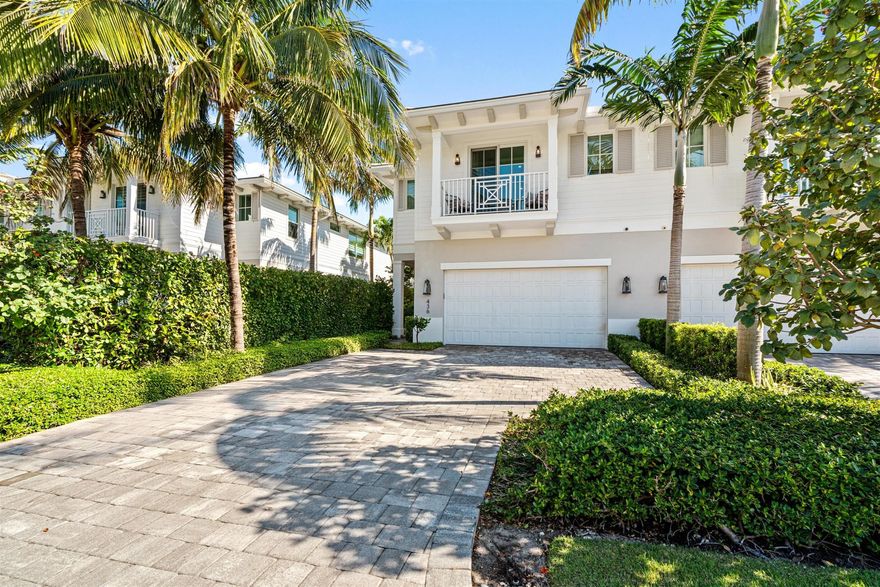 Experience the epitome of coastal luxury just one block from the beach in Boca Raton Riviera. This impeccably designed 2020-built townhome defines modern elegance, offering 3 beds, 3.1 baths, and 3,960+/- total sq ft. Features include soaring 10-ft ceilings, rich wood and large-format porcelain tile floors, custom moldings, and impact glass window-walls that seamlessly blend the interior with the lush tropical landscape. The open great room concept boasts a dramatic linear gas fireplace and built-in cabinetry. The gourmet island kitchen is a chef's dream with sleek contemporary cabinetry, Caesarstone countertops, professional-grade Thermador appliances, and a natural gas range. Upstairs, a loft connects the luxurious primary suite and two guest suites.