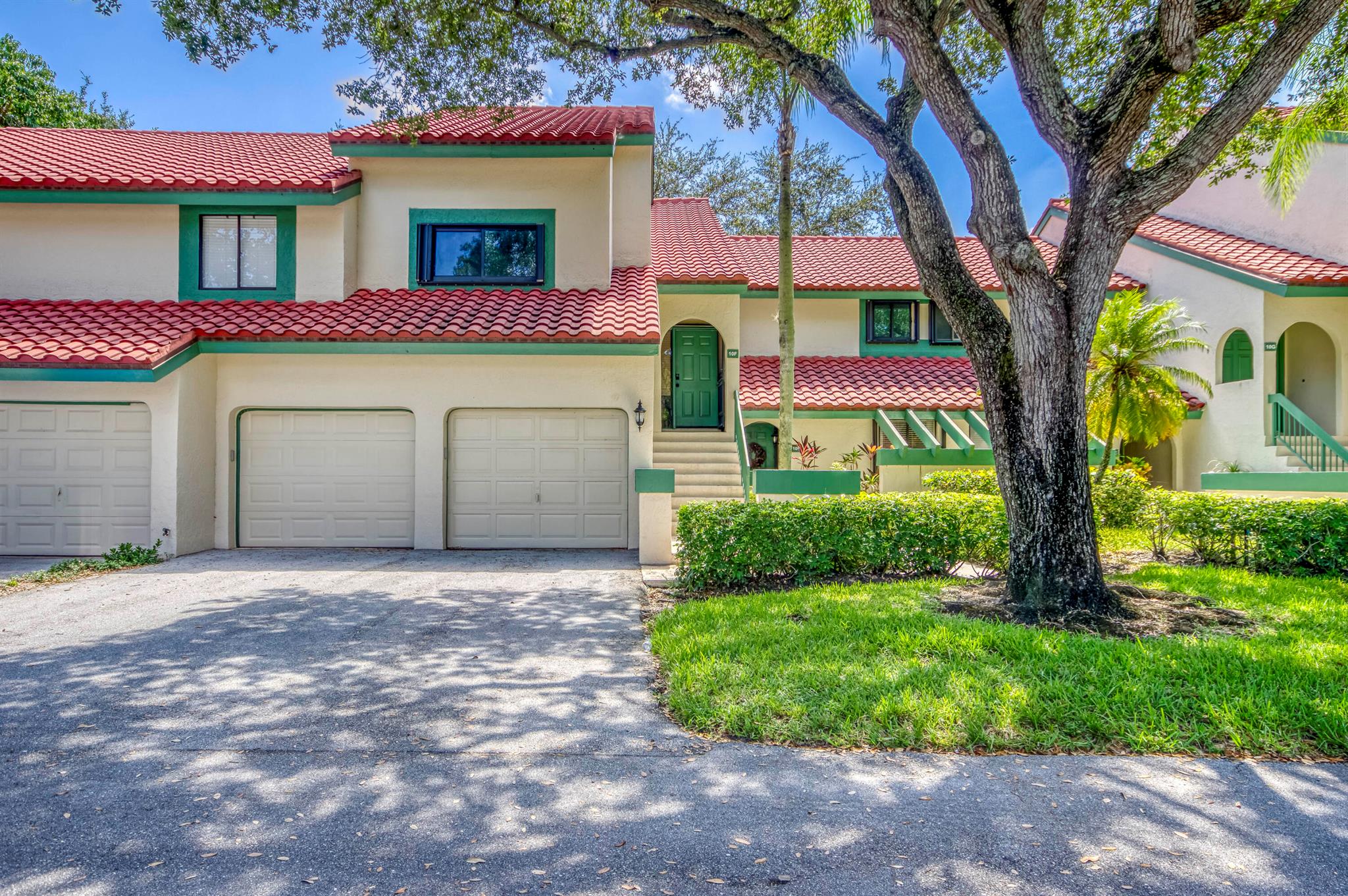 Welcome to this charming and light-filled first-floor condo in the desirable Lexington Green community of PGA National. Ideally positioned on a peaceful southeast corner lot, the home offers tranquil front-facing canal views and lush garden scenery in the rear. Blending an open layout with timeless Southern charm, it features warm cherry wood laminate flooring, a soft buttery cream and greige color palette, and crisp white plantation shutters throughout. The bright living and dining areas each enjoy sliding glass doors that fill the space with natural light and offer seamless flow to the screened, covered patio, perfect for lounging or dining in the shade of mature tropical landscaping. The updated kitchen (2017) is both stylish and functional, showcasing marble-look ceramic tile