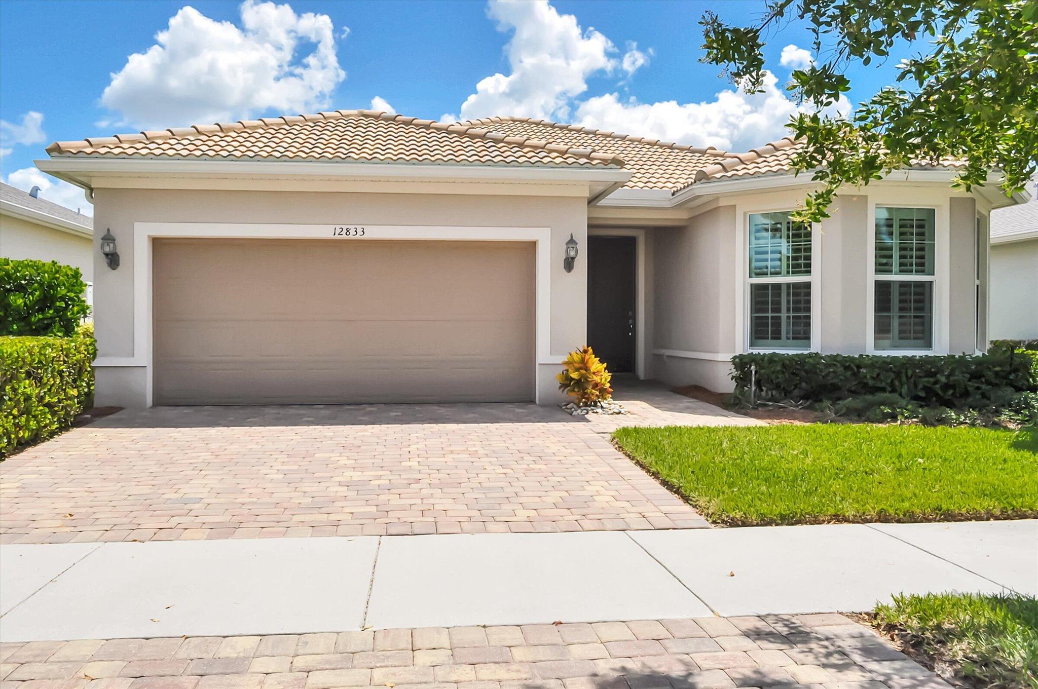 Feel like you're on vacation every day in this beautiful lake view home located in the desirable Del Webb Tradition 55+ active adult community in Port Saint Lucie. This thoughtfully designed 2-bedroom, 2-bath home with a versatile flex room that is perfect for an office, den, or hobbies.The heart of the home is the spacious, upgraded kitchen featuring crisp white cabinets, quartz countertops, a tile backsplash, pantry, and a large island with extra storage--ideal for entertaining or everyday living. Neutral porcelain plank tile flooring flows throughout, adding a modern touch and easy-care comfort. Additional features include a two-car garage with epoxy flooring and utility sink, and a tile roof. Plantation shutters, ceiling fans, washer and dryer.