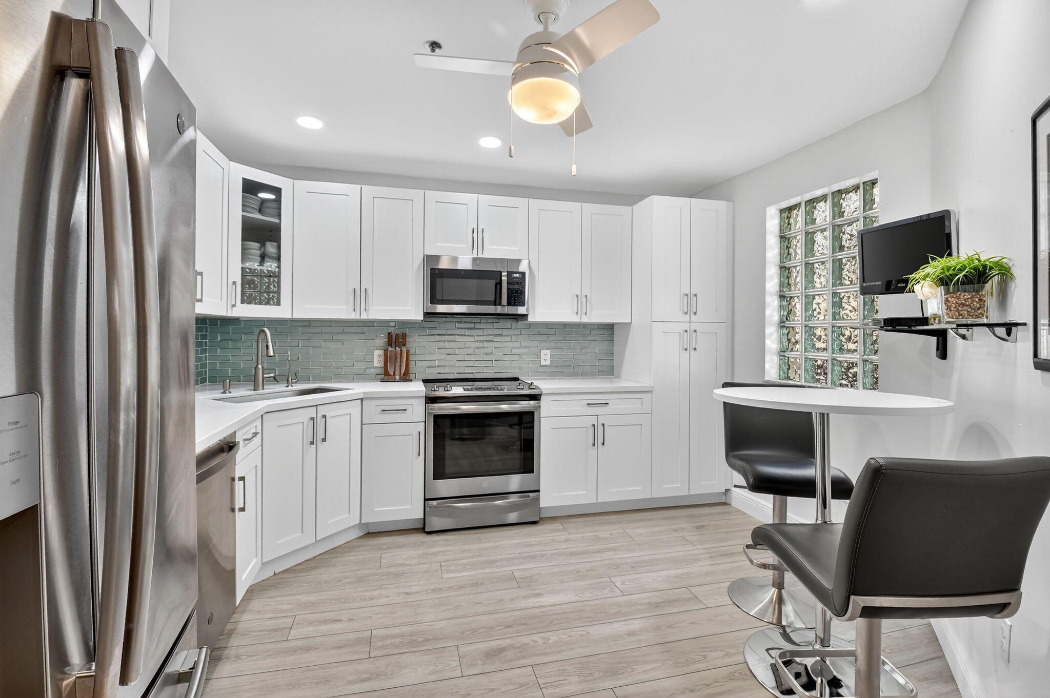 Welcome to this immaculate, fully renovated home where modern design meets resort-style living. Impeccably maintained and updated with top-quality finishes, this stunning unit offers seamless LVP flooring throughout and custom built-in shelving and drawers in the closets for maximum organization. The spacious kitchen is a showstopper, featuring newer stainless steel appliances, modern white shaker cabinets with soft-close doors, convenient pull-out drawers, and a full backsplash for a sleek, polished look. Enjoy peaceful lake views and the convenience of being located directly across from the clubhouse. Platina is a guard-gated, country club-style community with something for everyone--an updated and vibrant clubhouse, resort-style pool (including lap lanes), on-site restaurant,