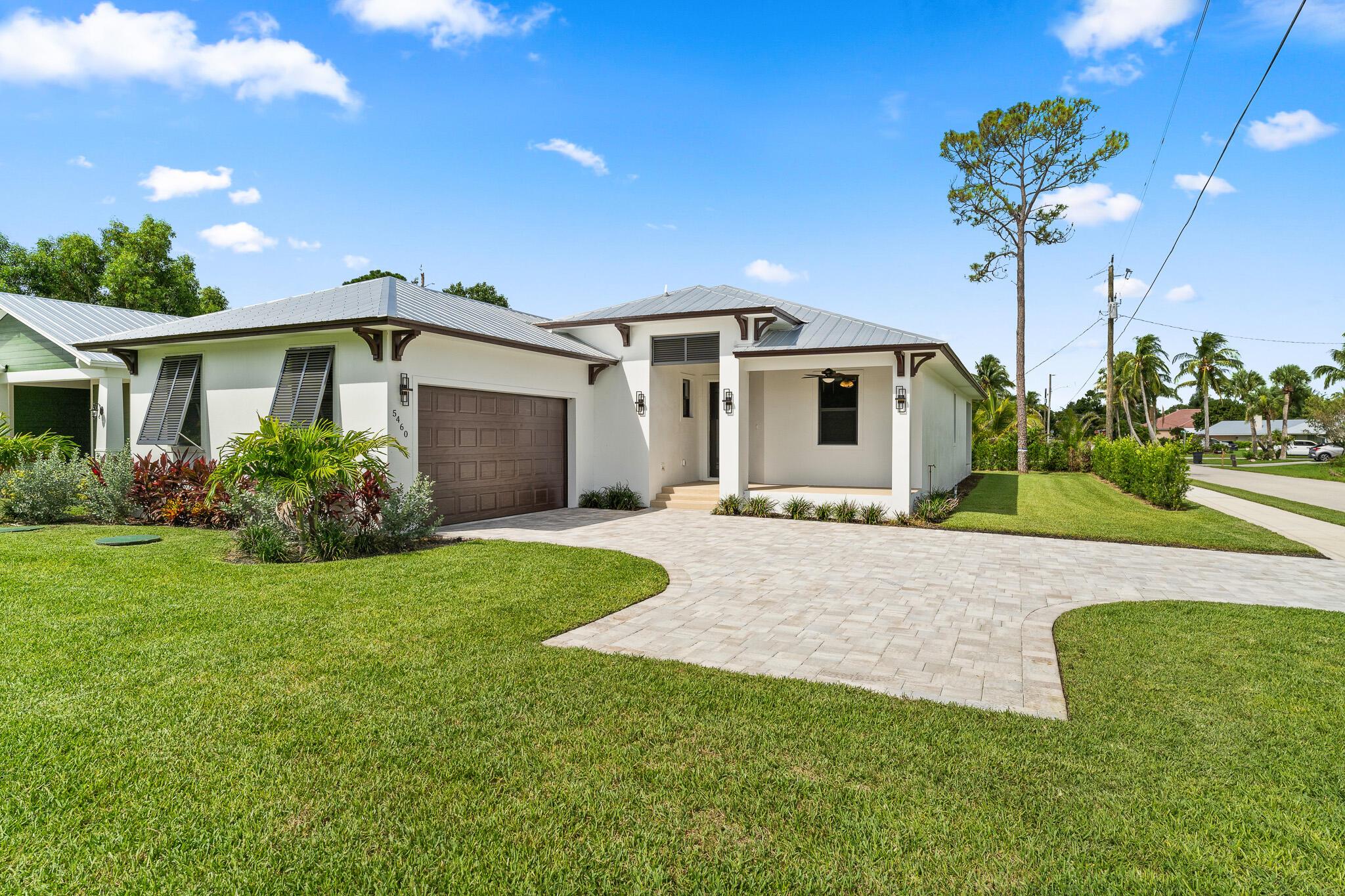 This thoughtfully designed 3 bedroom + den, 2.5 bath estate blends charm, quality, and convenience in one beautiful new build. Located just minutes from public boat ramps, Sandsprit Park, and Port Salerno's waterfront dining, this home is the perfect blend of lifestyle and location. Inside, enjoy an open-concept design with quartz countertops, a waterfall eat-in island, wood cabinetry and luxury porcelain tile throughout. Tray ceilings, crown molding, recessed lighting, and ceiling fans add elegance and comfort. Built for peace of mind and longevity with impact windows and doors, a metal roof, and stucco exterior. Relax on the elevated front or back patio with fresh coastal breezes. The oversized 10' garage door and large lot offer space for your boat, RV or fut