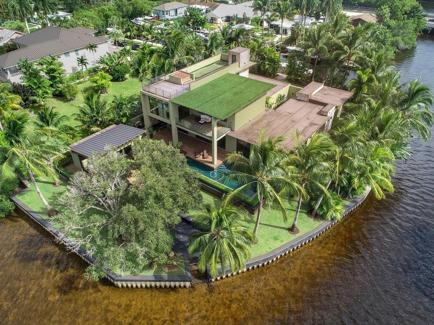 This modern masterpiece, nestled sumptuously amidst over 385 feet of waterfront, presents a stunning coda to this hushed Jupiter lane.  A stunning drive and entry way accentuated by the home's terraced roofline greets residents, presaging the artfully executed modern aesthetic inside.  Inside, sweeping ceilings preside over a tasteful open concept living area buttressed by mahogany accents.  The chic kitchen with best in class Jenn-Air appliances opens to the covered lanai and stylish pool and jacuzzi deck with panoramic views of the intercoastal waterway.  Ringed in palms, the exquisite outdoor space is complemented by a pool house with wet bar and powder room.   Retractable custom impact glass borders much of the home for a truly integrated indoor-outdoor aesthetic.