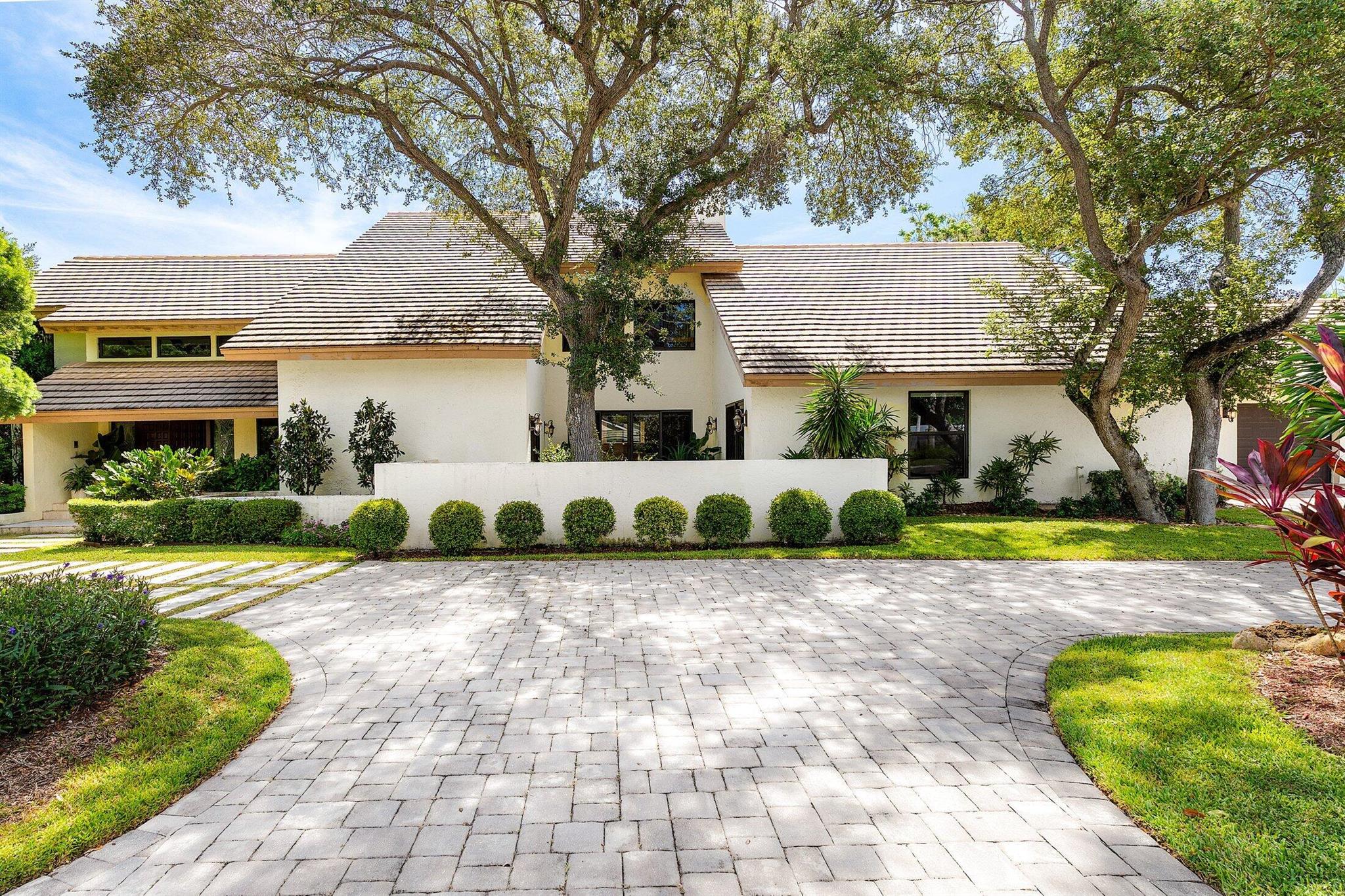 Nestled on a rare 16,552+/- SF lot in Boca Raton's most prestigious guard-gated waterfront community, The Sanctuary, this elegant 2-story residence offers 5,929+/- total SF of exceptional indoor-outdoor living. A circular drive and 3-car garage welcome you home to 4 spacious bedrooms, each with ensuite baths, plus 2 additional powder rooms, a formal dining room, family room, living room, eat-in kitchen, laundry, and versatile den.