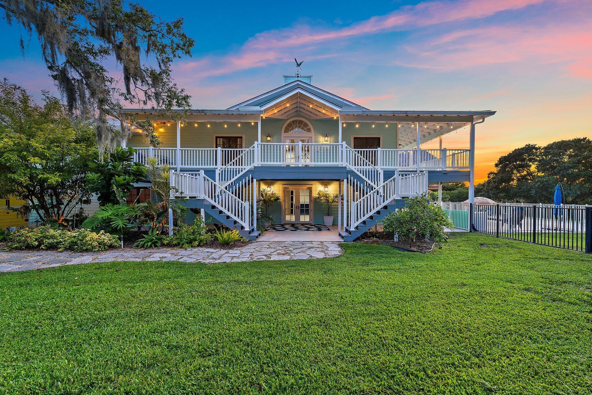 Experience luxury living in this stunning Key West-style estate on over 2 private acres! Boasting a metal roof, 5 beds, 4.5 baths plus a beautifully renovated 1/1 guest house, this 4,483 sq ft home features a 4-car garage, in-ground heated pool, and private creek with ocean access. Enjoy a gourmet kitchen with granite counters, Viking stove, and refinished cabinets. The spacious primary suite includes a balcony, dual walk-in closets, soaking tub, and double vanities. Recent upgrades include new AC units, luxury vinyl flooring and Generac whole-home generator. Gated entry, front/rear covered balconies, and prime location near A-rated schools, dining, and Martin County's serene waterfront make this home a rare find.