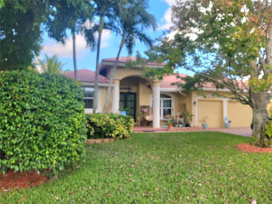 Impeccable 4-bed, 2-bath home. A hidden gem in the heart of Coral Springs. Canal view. Custom built. One owner since 1999. Entrance features a new impact glass door, with column in Foyer and a decorative art Marble inlay. Travertine Tiles in Living, Dining and kitchen area. Wood floor in Master bedroom and laminate in the other bedrooms. Impact glass. New Patio Deck with infinity pool and secured fence. Large master bedroom with a pool view. 2 walk-in closets. The Master bathroom boasts a Roman Tub, separate shower and 2 new vanities. Renovated open concept kitchen with 42" cabinets, granite countertop and matching backsplash. SS appliances. Stylish Kitchen Island. Spacious space to entertain. New privacy fence. 3 car garage. Serene and lovely community. Move-in ready.