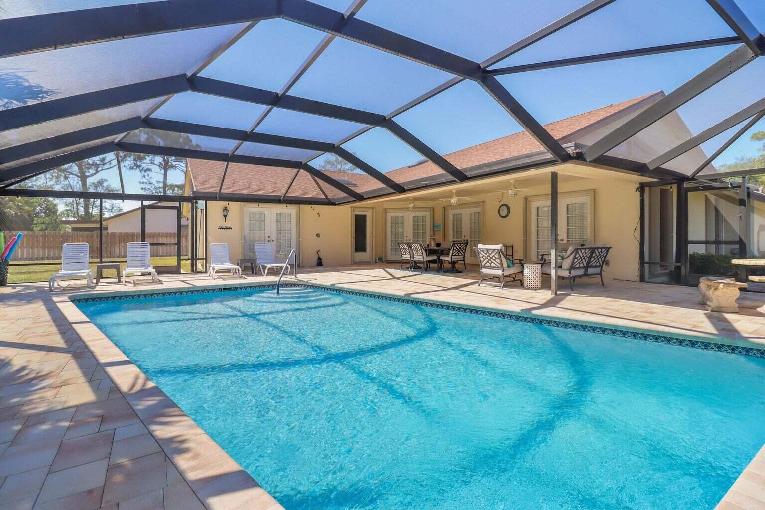 Enjoy this spacious ranch house on a corner lot with a completely fence in backyard space. Screened HEATED In-ground pool, covered patio with outdoor seating areas. Fully furnished including flat screen SMART TV's, WiFi, Water view , fresh linens and a kitchen stocked like your own home. En Suite Bedroom has a King Size Bed, 2nd Bedroom has 2 Queens Size beds and 3rd bedroom has 2 full size beds. All rooms have Smart TVs. Minutes from Equestrian Area, Shopping and restaurants. Convenient to Everything! Heart of Wellington. Pets allowed. Property is available for weekly rentals. Water, Wifi, Smart TV, Weekly Pool Service , Weekly landscaping included in rental pricing . PETS ALLOWED. 90 day rental or annual rental permitted.